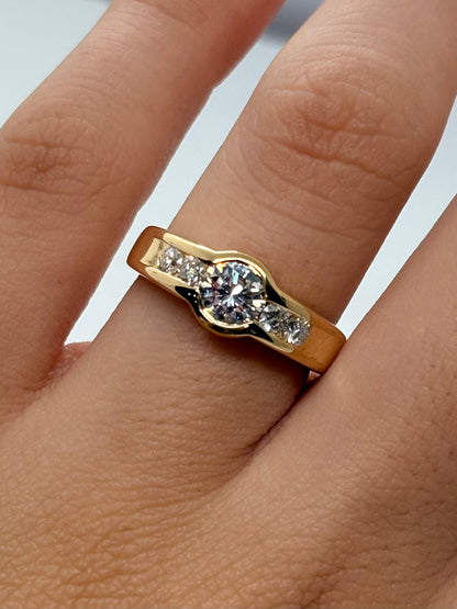Bague solitaire en or jaune 18 carats (750/1000) sertie de diamants naturels. Cette bague en or jaune et diamants séduit par son élégance intemporelle et son design raffiné. La brillance des pierres précieuses s’associe harmonieusement à la chaleur de l’or jaune pour créer un bijou lumineux. Idéale comme bague de fiançailles, bague solitaire diamant ou bijou de joaillerie, elle apporte une touche de sophistication au quotidien comme lors d’occasions spéciales. 