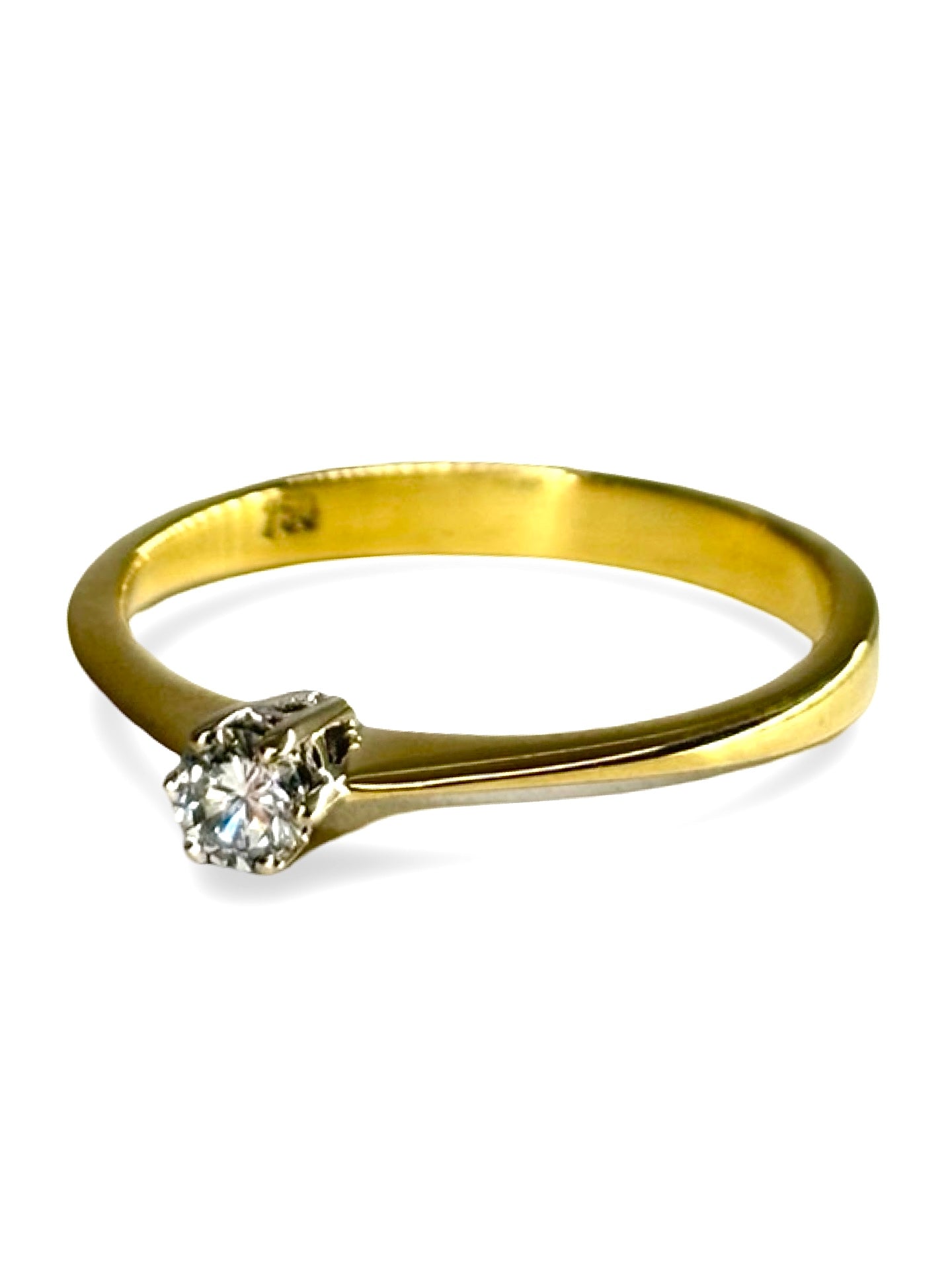 Solitaire en or jaune 18 carats serti d’un diamant taille brillant de 0,13 carat. Son design épuré met en valeur l’éclat naturel de la pierre et la chaleur lumineuse de l’or jaune. Élégante et intemporelle, cette bague incarne la simplicité raffinée et s’adapte aussi bien à une demande en mariage qu’à un bijou symbolique à porter au quotidien.