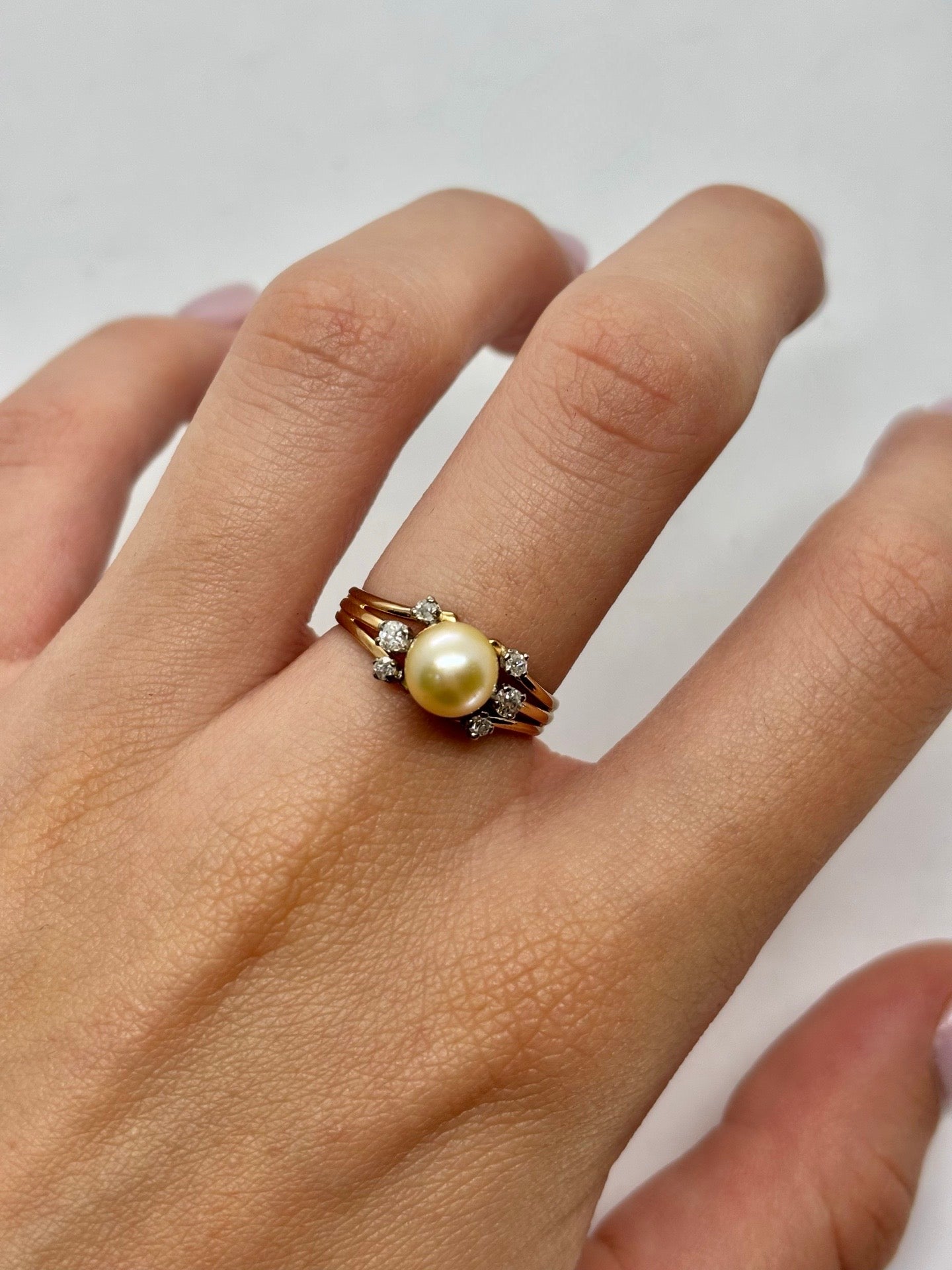 Bague ancienne en or jaune 18 carats mettant en valeur une élégante perle entourée de diamants totalisant 0,15 carat. Ce bijou de style vintage séduit par son raffinement intemporel, son éclat délicat et ses finitions soignées. Une bague ancienne idéale pour les amateurs de joaillerie de caractère, alliant la douceur de la perle à la brillance des diamants.
