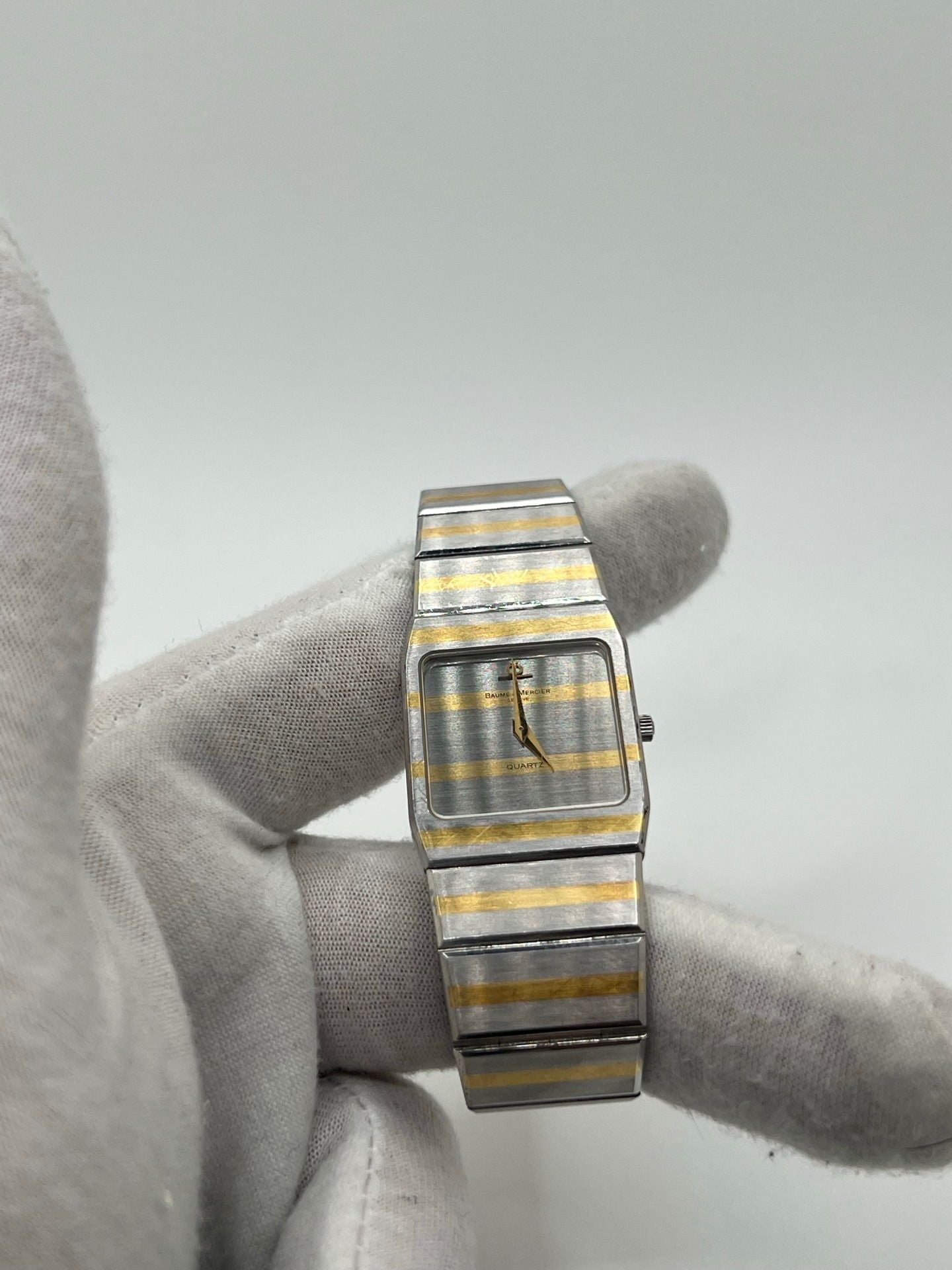 Montre Baume & Mercier Carlo Zebra 5739.038 pour homme/unisexe, mouvement quartz, boîtier acier 25x32 mm, cadran or, verre saphir et bracelet or/acier avec boucle pli. Étanche 10 ATM, d'occasion en bon état, disponible sans coffret ni papiers d'origine. Idéale pour les amateurs de montres de luxe élégantes et intemporelles.