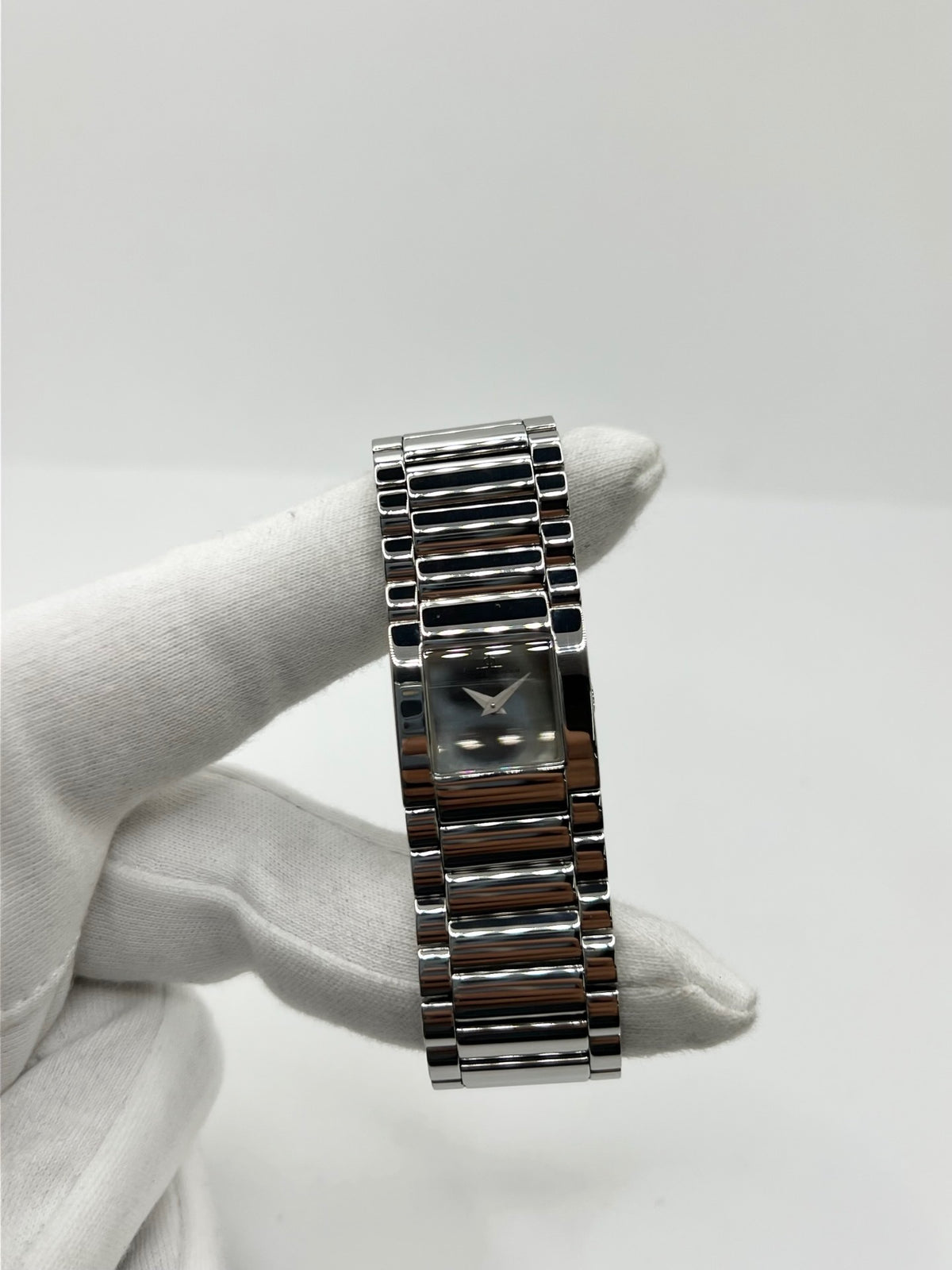 Montre femme Baume & Mercier Catwalk MV045219 à quartz, avec boîtier rectangulaire en acier de 24 x 21 mm, cadran argenté sans chiffres et bracelet en acier à boucle déployante double plis. Son verre saphir et son design élégant en font une montre raffinée et intemporelle. Cette Baume & Mercier Catwalk d’occasion est en très bon état, avec de légères rayures non perceptibles au toucher. Révisée en interne le 21 octobre 2026, elle est disponible à Paris sans coffret ni papiers d’origine.
