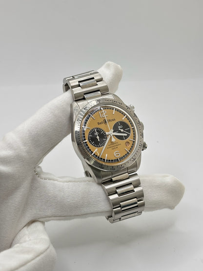 Montre Bell & Ross BR V2 Chronograph Heritage référence BRV2-94-S équipée d'un mouvement automatique. Son boîtier en acier de 41 mm est associé à un bracelet en acier argenté avec boucle déployante double plis. Le cadran doré à chiffres arabes est protégé par un verre minéral et intègre les fonctions chronographe et date. Cette montre d'occasion, révisée en interne et proposée en très bon état, allie esprit aviation, design vintage et précision horlogère suisse.