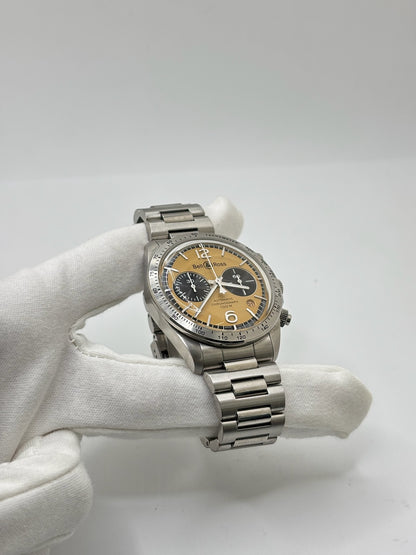 Montre Bell & Ross BR V2 Chronograph Heritage référence BRV2-94-S équipée d'un mouvement automatique. Son boîtier en acier de 41 mm est associé à un bracelet en acier argenté avec boucle déployante double plis. Le cadran doré à chiffres arabes est protégé par un verre minéral et intègre les fonctions chronographe et date. Cette montre d'occasion, révisée en interne et proposée en très bon état, allie esprit aviation, design vintage et précision horlogère suisse.