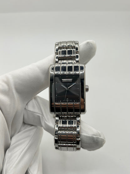 Montre Boucheron Reflet Icare Parallèle en acier, boîtier rectangulaire de 28 x 40 mm avec verre saphir et cadran gris à index bâtons. Équipée d’un mouvement quartz fiable et d’un bracelet en acier avec boucle double déployante. Fonction date discrète. Modèle élégant au design graphique emblématique de la collection Reflet. Montre d’occasion en très bon état, présentant de légères micro-rayures, révisée en interne, sans coffret ni papiers d’origine.