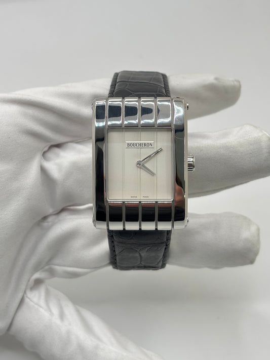 Montre Boucheron Reflet Icare Parallèle en acier, équipée d’un mouvement quartz précis. Boîtier rectangulaire 28 x 40 mm avec verre saphir et cadran blanc épuré. Bracelet en cuir de crocodile noir avec boucle ardillon en acier. Modèle homme/unisexe au design élégant et intemporel. Montre d’occasion en très bon état, présentant de légères traces d’usure non perceptibles au toucher, révisée en avril 2026, idéale pour amateurs d’horlogerie et de pièces de luxe.