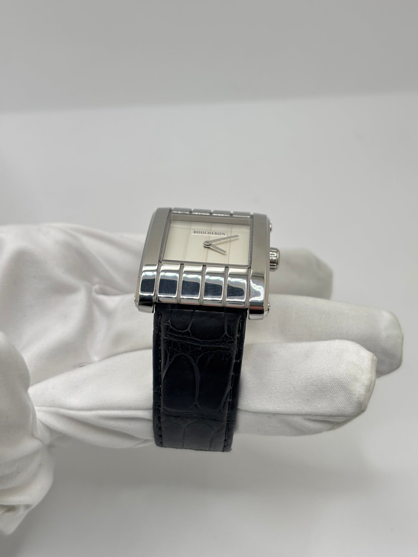 Montre Boucheron Reflet Icare Parallèle en acier, équipée d’un mouvement quartz précis. Boîtier rectangulaire 28 x 40 mm avec verre saphir et cadran blanc épuré. Bracelet en cuir de crocodile noir avec boucle ardillon en acier. Modèle homme/unisexe au design élégant et intemporel. Montre d’occasion en très bon état, présentant de légères traces d’usure non perceptibles au toucher, révisée en avril 2026, idéale pour amateurs d’horlogerie et de pièces de luxe.