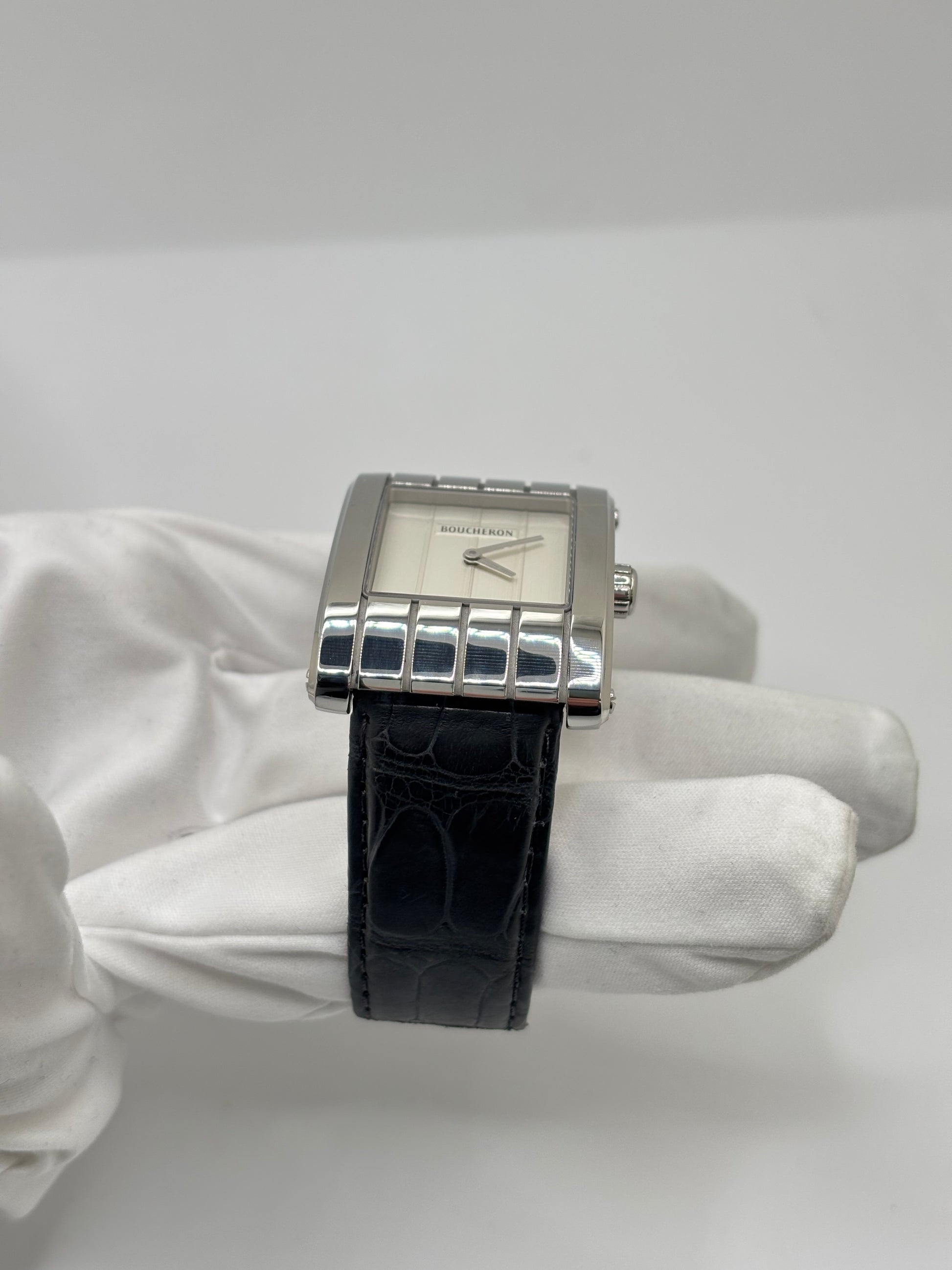 Montre Boucheron Reflet Icare Parallèle en acier, équipée d’un mouvement quartz précis. Boîtier rectangulaire 28 x 40 mm avec verre saphir et cadran blanc épuré. Bracelet en cuir de crocodile noir avec boucle ardillon en acier. Modèle homme/unisexe au design élégant et intemporel. Montre d’occasion en très bon état, présentant de légères traces d’usure non perceptibles au toucher, révisée en avril 2026, idéale pour amateurs d’horlogerie et de pièces de luxe.