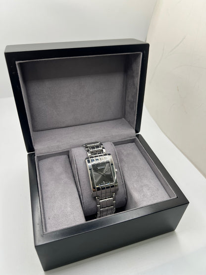 Montre Boucheron Reflet Icare Parallèle en acier, boîtier rectangulaire de 28 x 40 mm avec verre saphir et cadran gris à index bâtons. Équipée d’un mouvement quartz fiable et d’un bracelet en acier avec boucle double déployante. Fonction date discrète. Modèle élégant au design graphique emblématique de la collection Reflet. Montre d’occasion en très bon état, présentant de légères micro-rayures, révisée en interne, sans coffret ni papiers d’origine.
