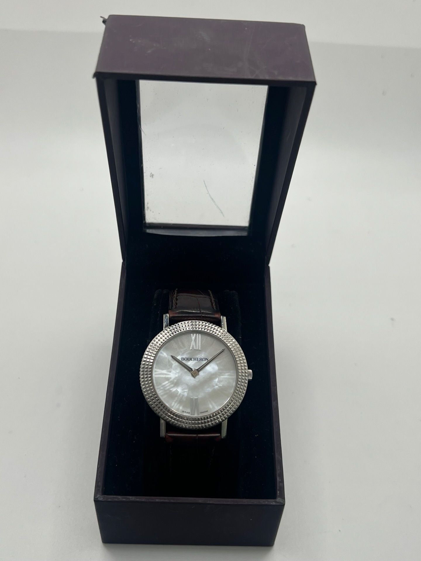 Découvrez l’élégance intemporelle de la Boucheron Ronde Clous de Paris, une montre Boucheron haut de gamme alliant raffinement et savoir-faire horloger. Ce modèle Ronde Clous de Paris se distingue par son cadran en nacre, subtilement mis en valeur par un boîtier en acier de 38 mm et un bracelet en peau d’alligator brun, synonyme de luxe et de confort.