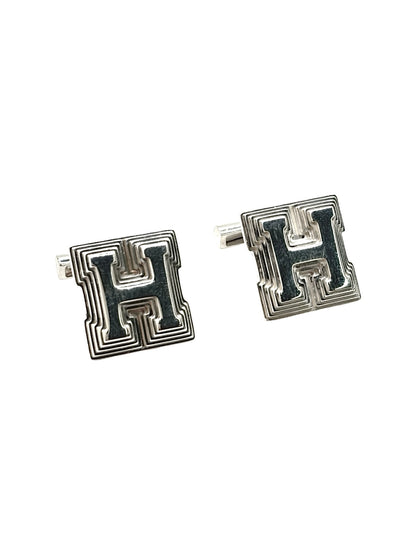Boutons de manchettes Hermès en argent 925 au design élégant et intemporel. Cette paire raffinée en argent massif reflète le savoir-faire de la maison Hermès avec des finitions soignées et un style sophistiqué. Accessoires de luxe idéals pour accompagner une tenue habillée, un costume ou une cérémonie. Boutons de manchettes précieux alliant raffinement, élégance masculine et qualité joaillière dans un esprit chic et contemporain.