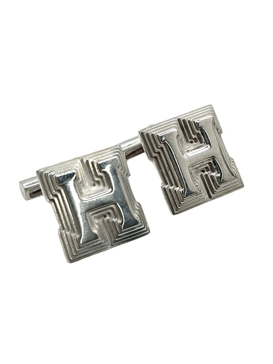 Boutons de manchettes Hermès en argent 925 au style élégant et intemporel. Cette paire raffinée en argent massif séduit par ses finitions soignées et son design sophistiqué caractéristique du savoir-faire Hermès. Accessoires de luxe parfaits pour compléter un costume, une tenue habillée ou une cérémonie. Boutons de manchettes précieux alliant distinction, élégance masculine et qualité joaillière dans un esprit chic et contemporain.