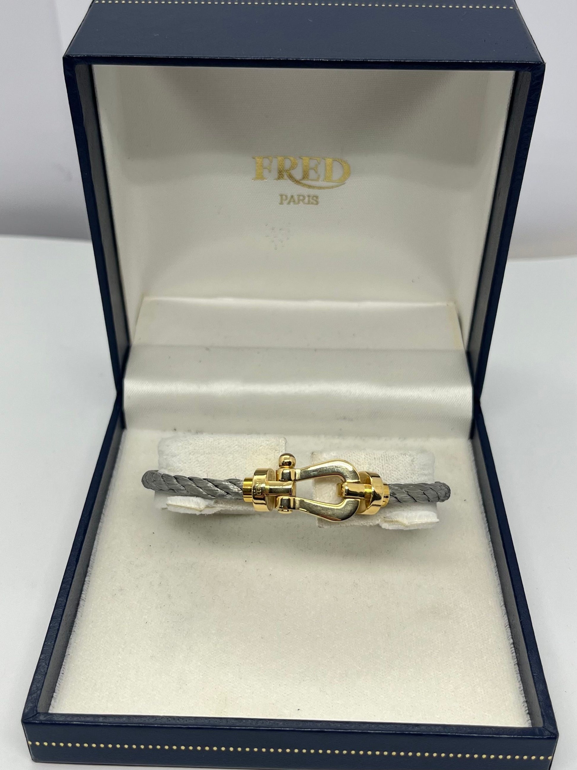 Icône de la Maison Fred, le bracelet Force 10 Grand Modèle en or jaune allie élégance et esprit marin. Son design tressé emblématique évoque la force et la liberté. Un bijou audacieux et raffiné, idéal pour sublimer un poignet avec caractère. Parfait en pièce signature ou à offrir en symbole de lien fort.

