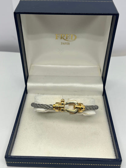 Icône de la Maison Fred, le bracelet Force 10 Grand Modèle en or jaune allie élégance et esprit marin. Son design tressé emblématique évoque la force et la liberté. Un bijou audacieux et raffiné, idéal pour sublimer un poignet avec caractère. Parfait en pièce signature ou à offrir en symbole de lien fort.

