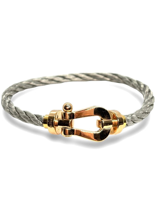 Icône de la Maison Fred, le bracelet Force 10 Grand Modèle en or rose allie élégance et esprit marin. Son design tressé emblématique évoque la force et la liberté. Un bijou audacieux et raffiné, idéal pour sublimer un poignet avec caractère. Parfait en pièce signature ou à offrir en symbole de lien fort.