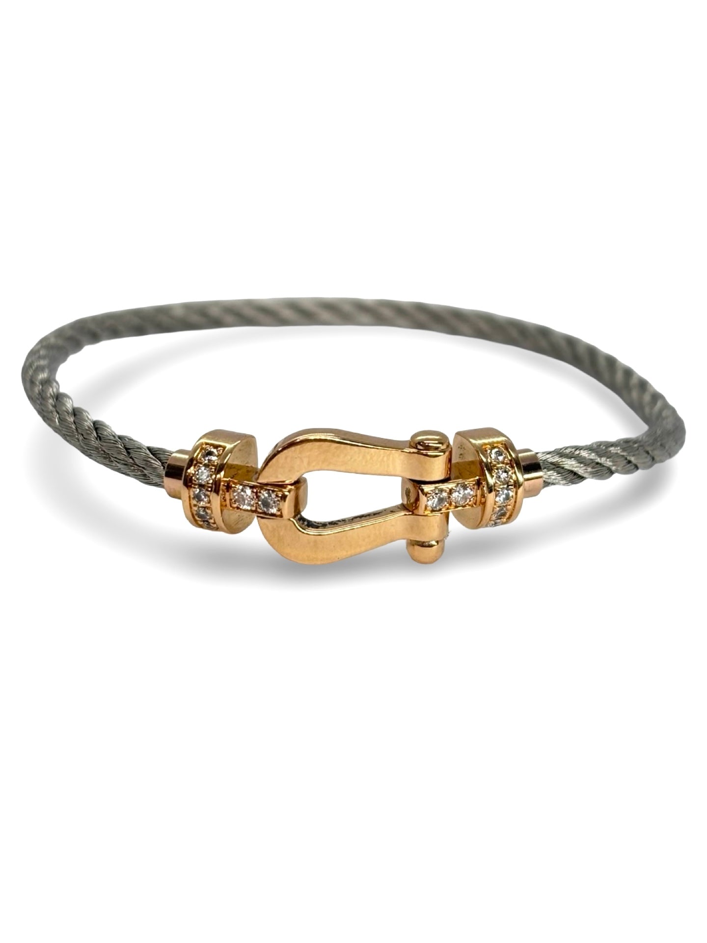 Icône de la Maison Fred, le bracelet Force 10 en or rose et diamants 0,12 ct allie élégance et modernité. Son câble tressé et sa boucle sertie de diamants reflètent un savoir-faire joaillier unique. Symbole de force et de raffinement, il sublime le poignet avec éclat et sophistication.