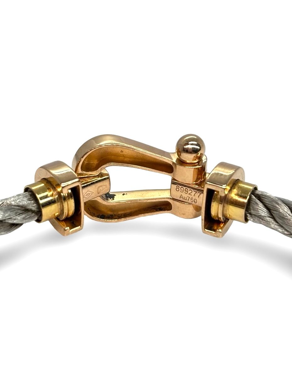 Icône de la Maison Fred, le bracelet Force 10 Grand Modèle en or rose allie élégance et esprit marin. Son design tressé emblématique évoque la force et la liberté. Un bijou audacieux et raffiné, idéal pour sublimer un poignet avec caractère. Parfait en pièce signature ou à offrir en symbole de lien fort.