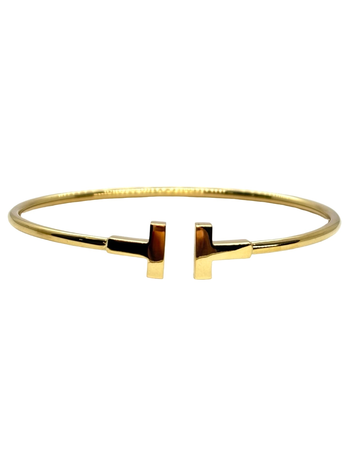 Bracelet Tiffany T Wire de Tiffany & Co en or jaune 18 carats. Ce jonc iconique au design épuré et moderne incarne l’élégance contemporaine de la maison joaillière. Sa ligne graphique et intemporelle en fait un bijou facile à porter au quotidien comme lors d’occasions spéciales, symbole de raffinement et de style affirmé.