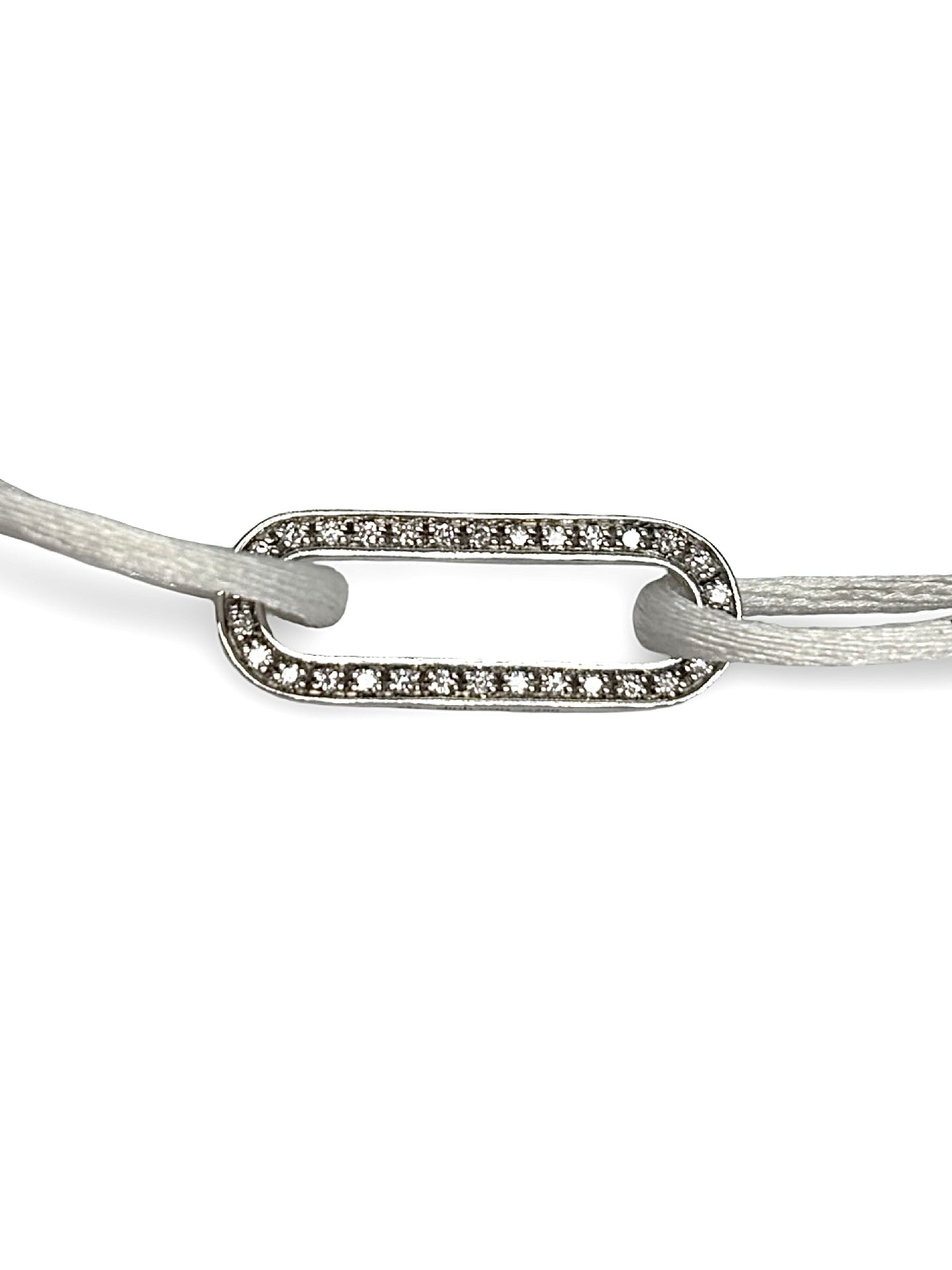 Bracelet cordon Dinh Van Maillon L en or blanc serti de diamants. Son design minimaliste et raffiné exprime l’élégance intemporelle propre à la maison Dinh Van. Le maillon emblématique symbolise le lien et la modernité, offrant un bijou lumineux et délicat à porter chaque jour, seul ou en accumulation.