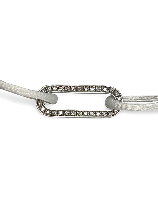 Bracelet cordon Dinh Van Maillon L en or blanc serti de diamants. Son design minimaliste et raffiné exprime l’élégance intemporelle propre à la maison Dinh Van. Le maillon emblématique symbolise le lien et la modernité, offrant un bijou lumineux et délicat à porter chaque jour, seul ou en accumulation.
