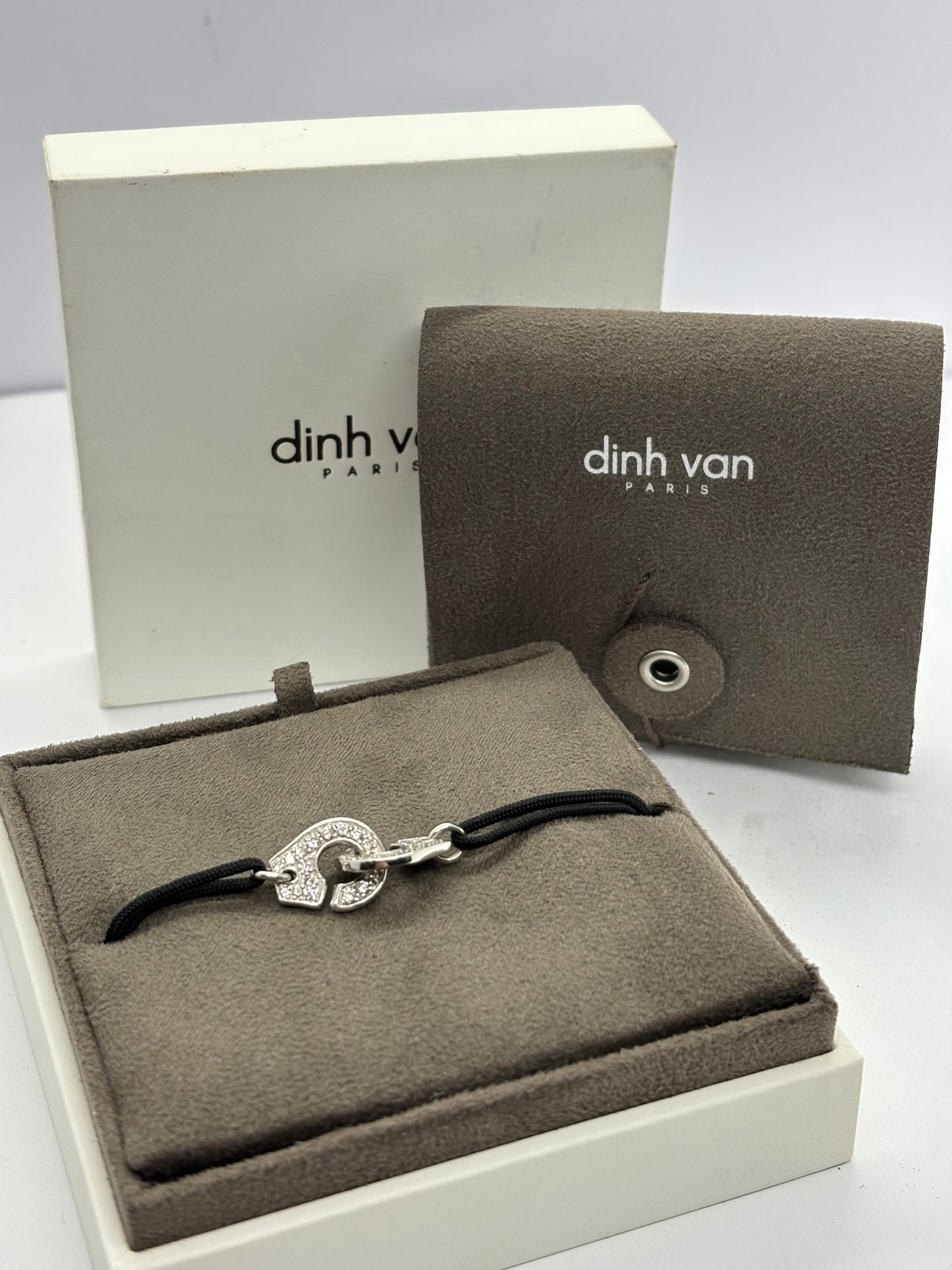 Bracelet Dinh Van Menottes en or blanc serti de diamants, symbole d’union et de modernité. Son design épuré et contemporain mêle éclat du métal précieux et brillance des pierres. Une création élégante et intemporelle, parfaite pour sublimer le poignet avec raffinement et discrétion.