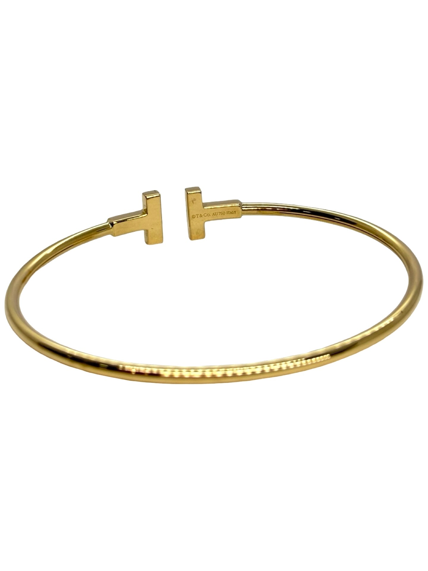 Bracelet Tiffany T Wire de Tiffany & Co en or jaune 18 carats. Ce jonc iconique au design épuré et moderne incarne l’élégance contemporaine de la maison joaillière. Sa ligne graphique et intemporelle en fait un bijou facile à porter au quotidien comme lors d’occasions spéciales, symbole de raffinement et de style affirmé.