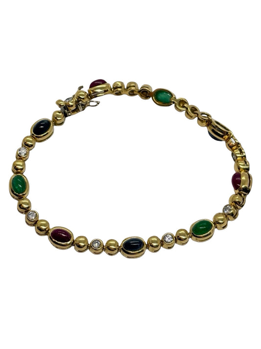 Bracelet en or jaune 18K serti de diamants 0,60 ct, d’émeraudes 1,70 ct, de rubis 2,40 ct et de saphirs 2,40 ct. Bijou précieux au design raffiné et coloré, alliant éclat des pierres et élégance de l’or jaune. Une pièce luxueuse et intemporelle, idéale pour sublimer le poignet avec sophistication et caractère, parfaite pour une collection de haute joaillerie.