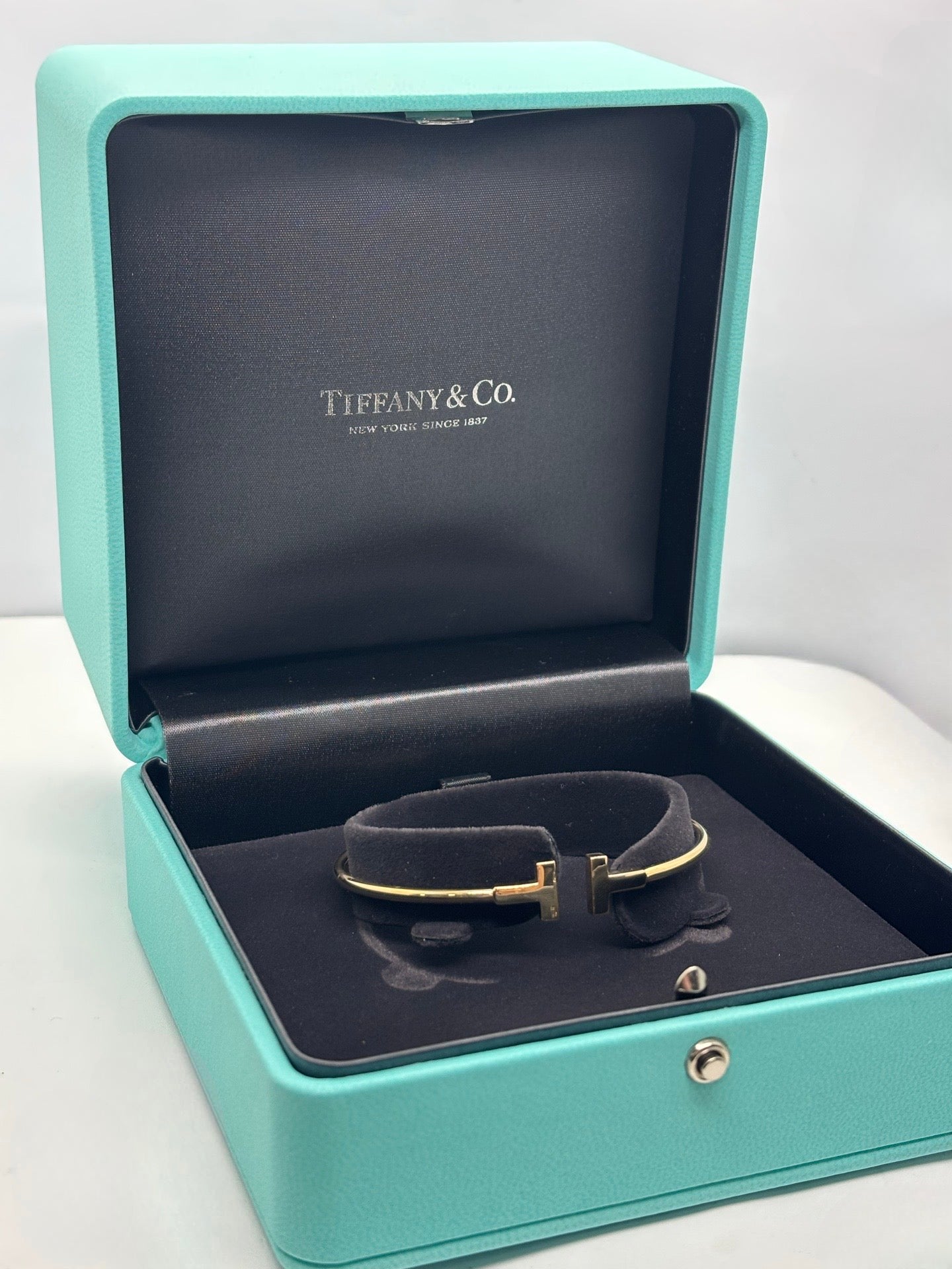 Bracelet Tiffany T Wire de Tiffany & Co en or jaune 18 carats. Ce jonc iconique au design épuré et moderne incarne l’élégance contemporaine de la maison joaillière. Sa ligne graphique et intemporelle en fait un bijou facile à porter au quotidien comme lors d’occasions spéciales, symbole de raffinement et de style affirmé.