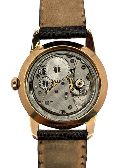 Montre Breitling Genève 2907 à remontage manuel, dotée d’un boîtier plaqué or de 35 mm et d’un calibre 220. Son cadran blanc est protégé par un verre Plexiglas et associé à un bracelet en cuir de lézard noir avec boucle ardillon en acier. Cette montre vintage Breitling Genève 2907, en très bon état, présente de légères traces d’usure. Révisée en interne en septembre 2026, elle est proposée sans coffret ni papiers d’origine.