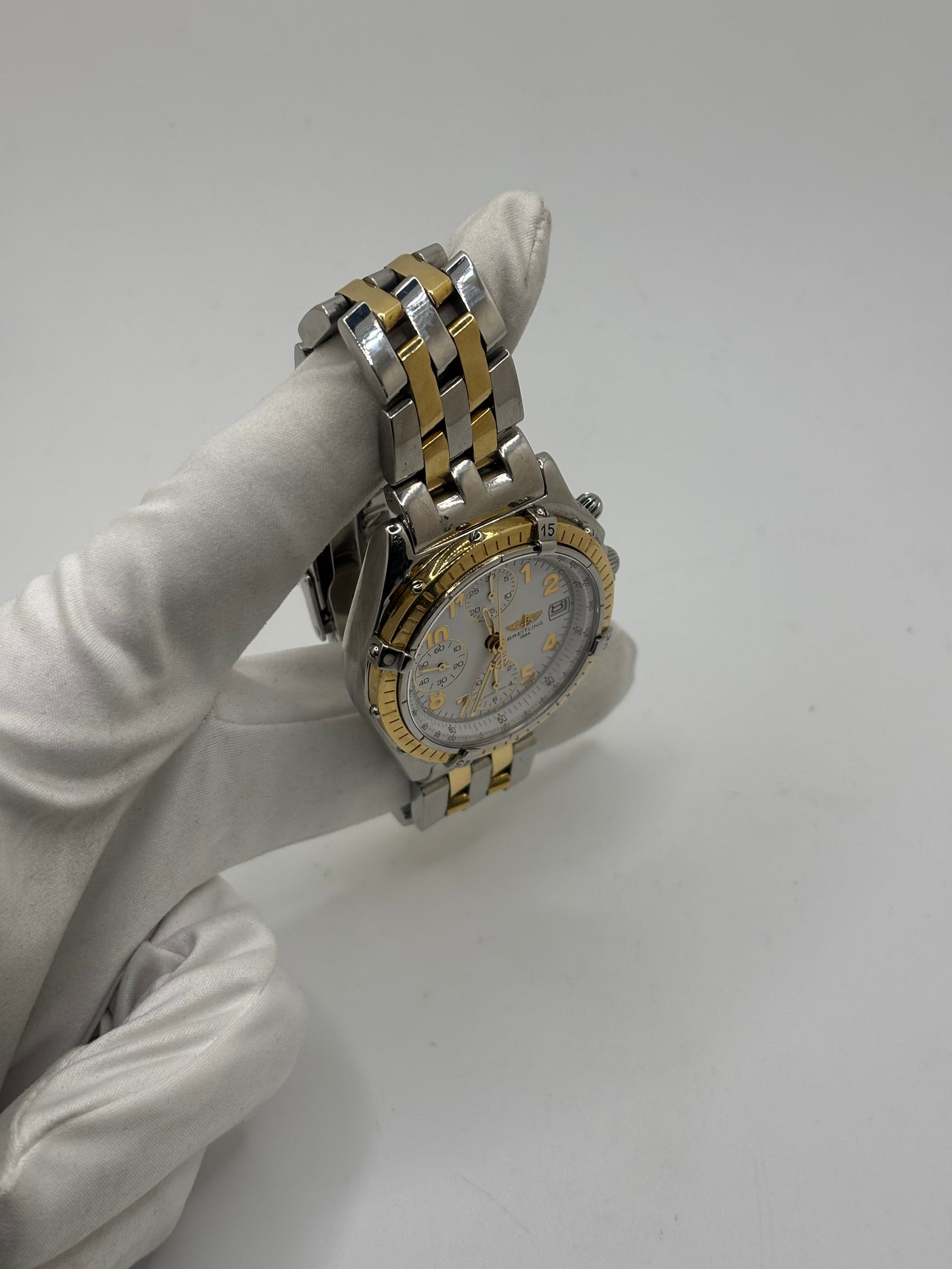 Montre Breitling Chronomat B13050.1 en or et acier avec boîtier de 39 mm, cadran blanc à chiffres arabes, verre saphir et mouvement automatique Breitling 13 basé sur l'ETA Valjoux 7750. Ce chronographe est équipé d'un bracelet en or et acier avec boucle déployante d'origine. Révisée, en excellent état et garantie 1 an, cette montre de luxe suisse allie élégance intemporelle, précision horlogère et finitions haut de gamme.