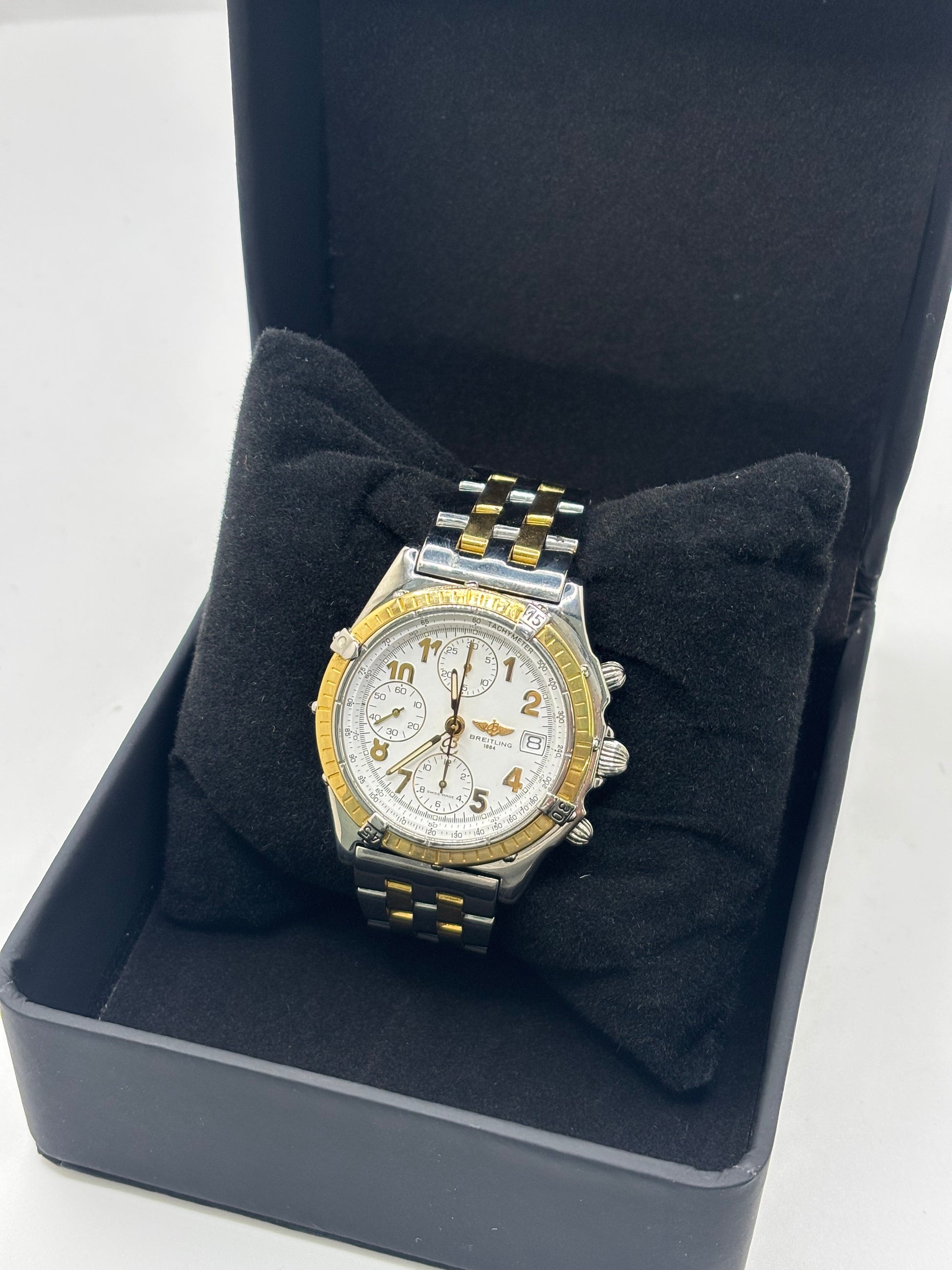 Montre Breitling Chronomat B13050.1 en or et acier avec boîtier de 39 mm, cadran blanc à chiffres arabes, verre saphir et mouvement automatique Breitling 13 basé sur l'ETA Valjoux 7750. Ce chronographe est équipé d'un bracelet en or et acier avec boucle déployante d'origine. Révisée, en excellent état et garantie 1 an, cette montre de luxe suisse allie élégance intemporelle, précision horlogère et finitions haut de gamme.