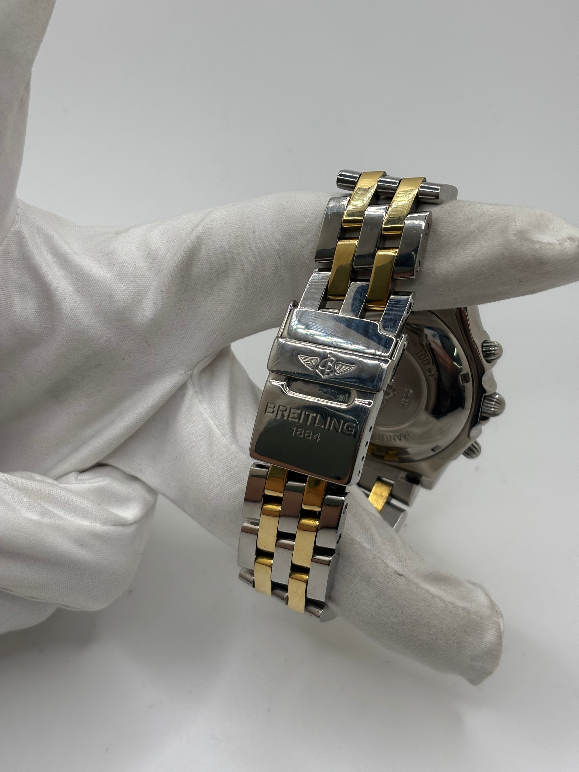 Montre Breitling Chronomat B13050.1 en or et acier avec boîtier de 39 mm, cadran blanc à chiffres arabes, verre saphir et mouvement automatique Breitling 13 basé sur l'ETA Valjoux 7750. Ce chronographe est équipé d'un bracelet en or et acier avec boucle déployante d'origine. Révisée, en excellent état et garantie 1 an, cette montre de luxe suisse allie élégance intemporelle, précision horlogère et finitions haut de gamme.