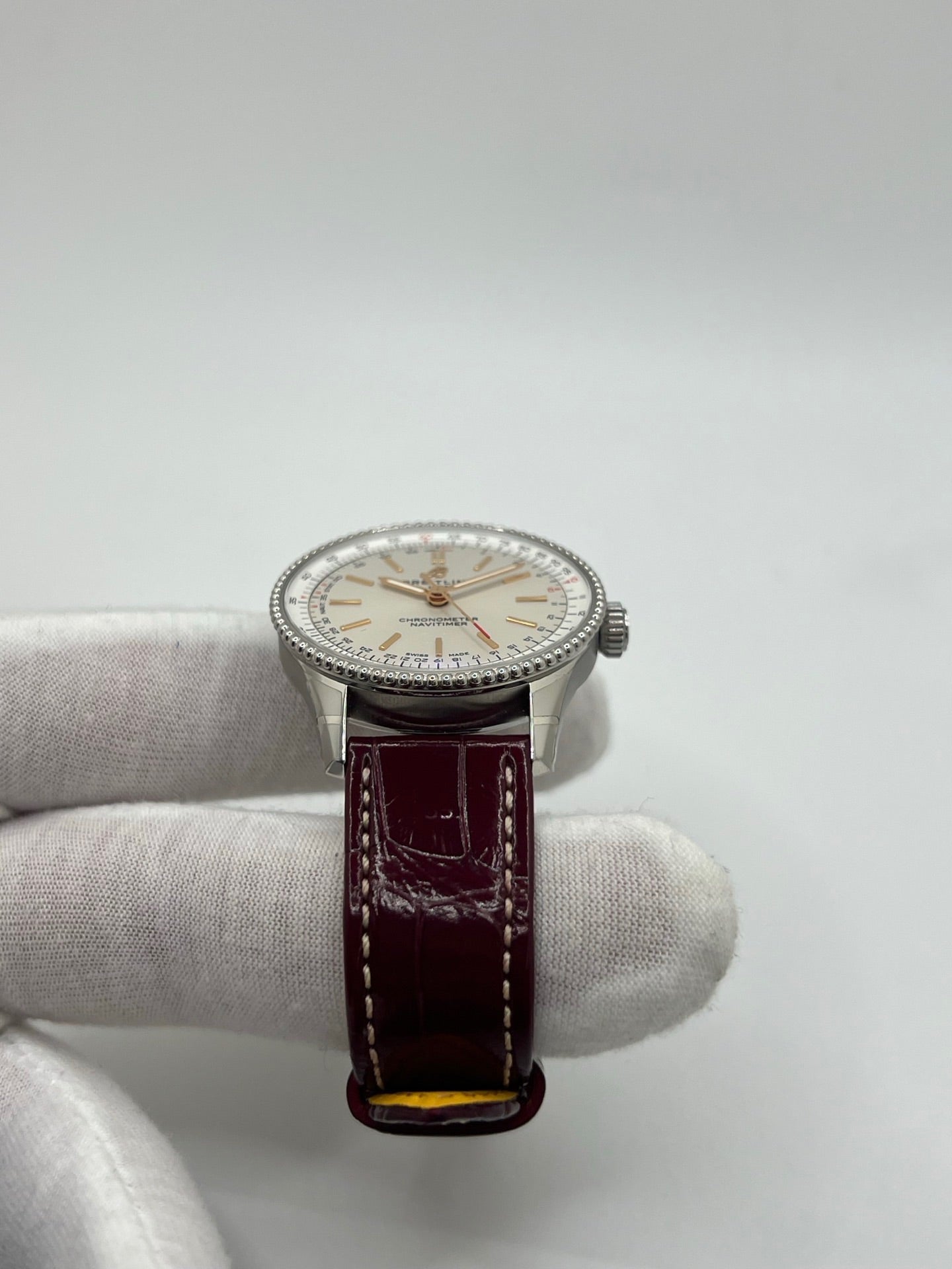 Montre Breitling Navitimer A17327211G1P1 pour femme, modèle automatique en acier de 36 mm avec cadran argent sans chiffres et verre saphir. Cette montre de luxe dispose du calibre Breitling 17 avec une réserve de marche de 38 heures. Elle est équipée d’un bracelet en cuir bordeaux avec boucle déployante en acier. Montre étanche à 3 ATM, état neuf, jamais portée, sans coffret ni papiers d’origine.