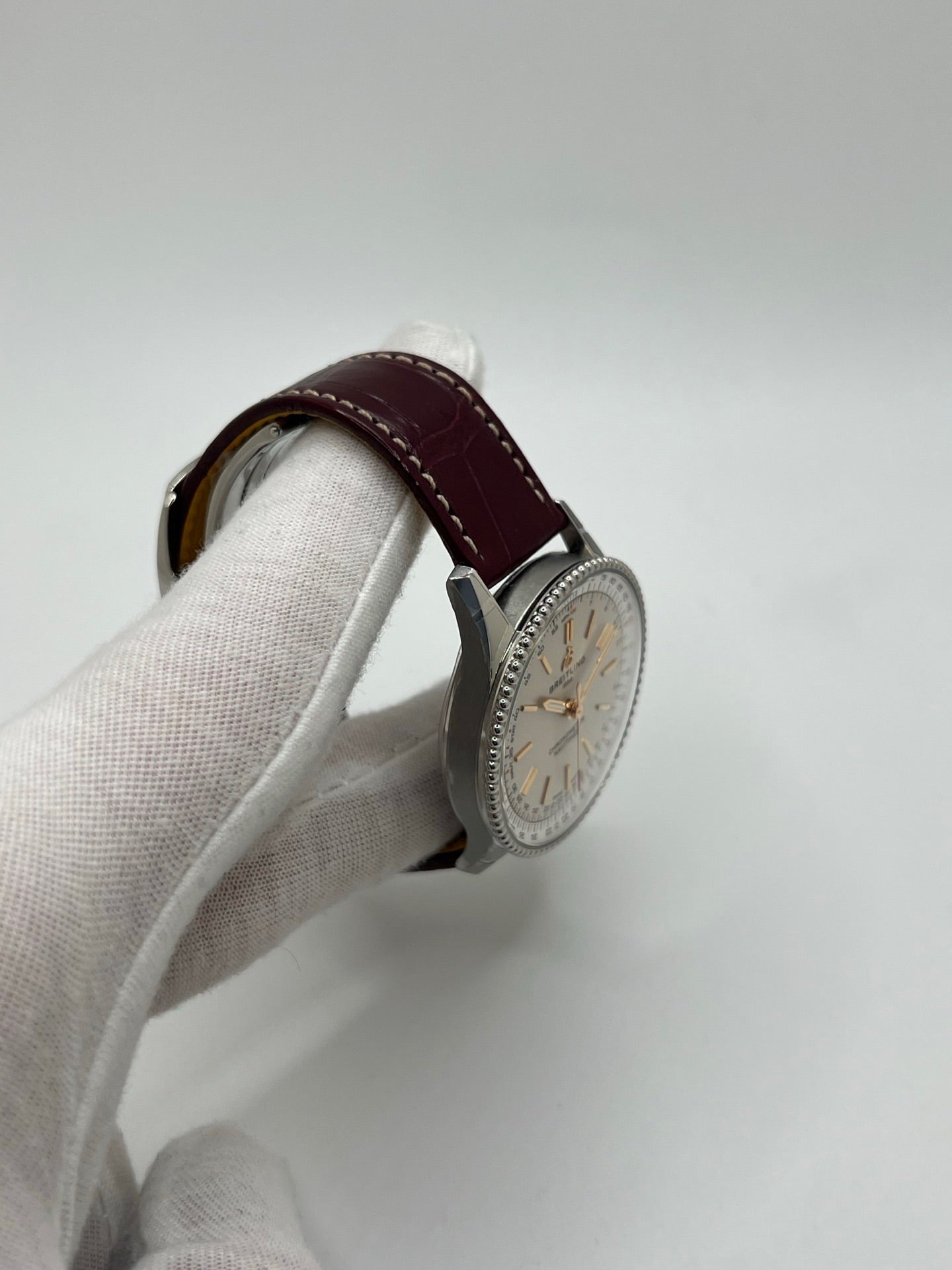 Montre Breitling Navitimer A17327211G1P1 pour femme, modèle automatique en acier de 36 mm avec cadran argent sans chiffres et verre saphir. Cette montre de luxe dispose du calibre Breitling 17 avec une réserve de marche de 38 heures. Elle est équipée d’un bracelet en cuir bordeaux avec boucle déployante en acier. Montre étanche à 3 ATM, état neuf, jamais portée, sans coffret ni papiers d’origine.