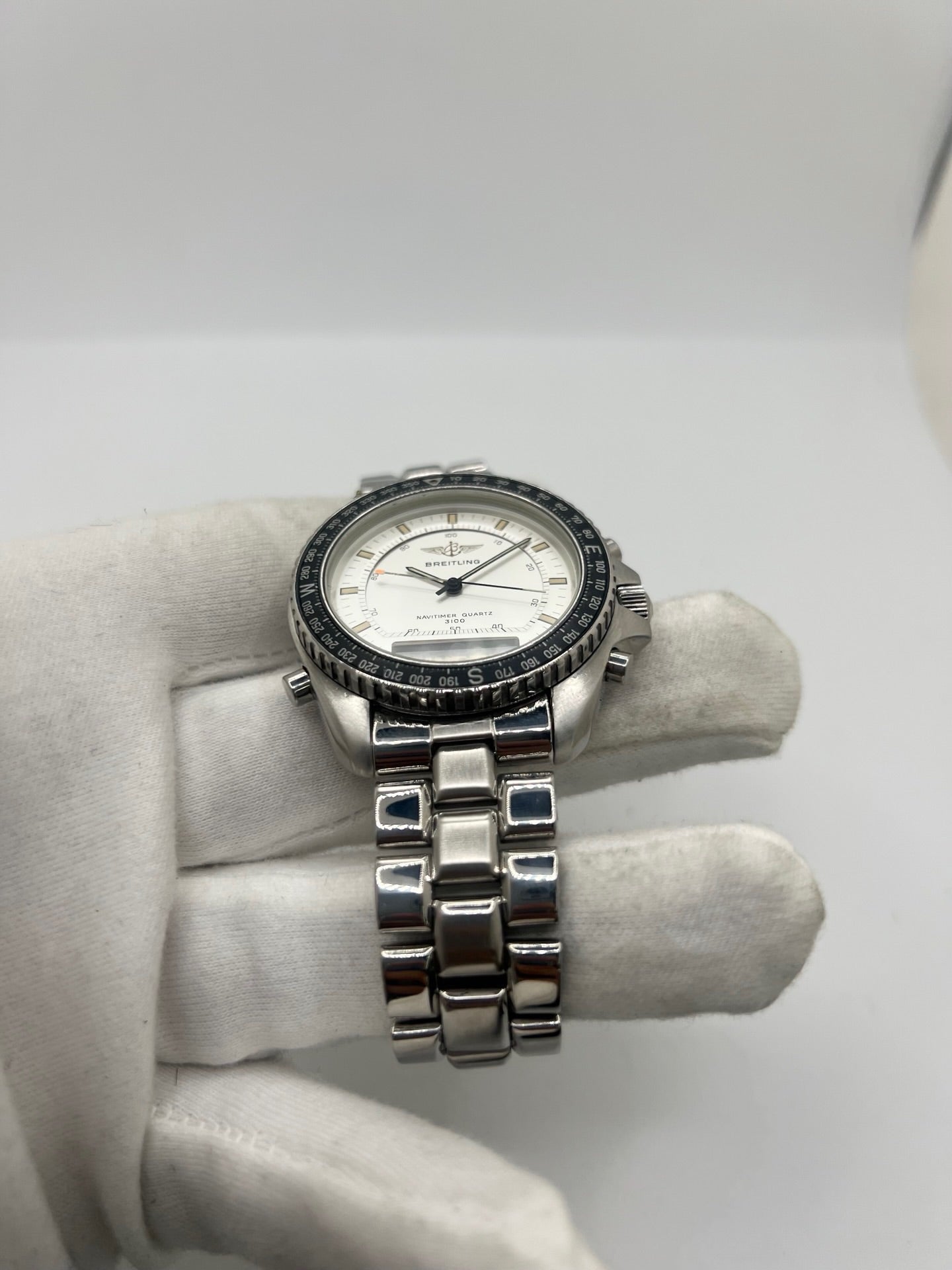 Montre Breitling Navitimer Pluton réf. 80191 en acier avec mouvement à quartz, cadran blanc à index sertis, verre saphir et lunette tournante. Ce chronographe est équipé d'un bracelet en acier avec boucle déployante, offrant robustesse et confort au quotidien. Son boîtier de 41 mm affirme un style sportif emblématique. Cette Breitling Navitimer Pluton d'occasion est en très bon état, révisée en interne et disponible immédiatement.