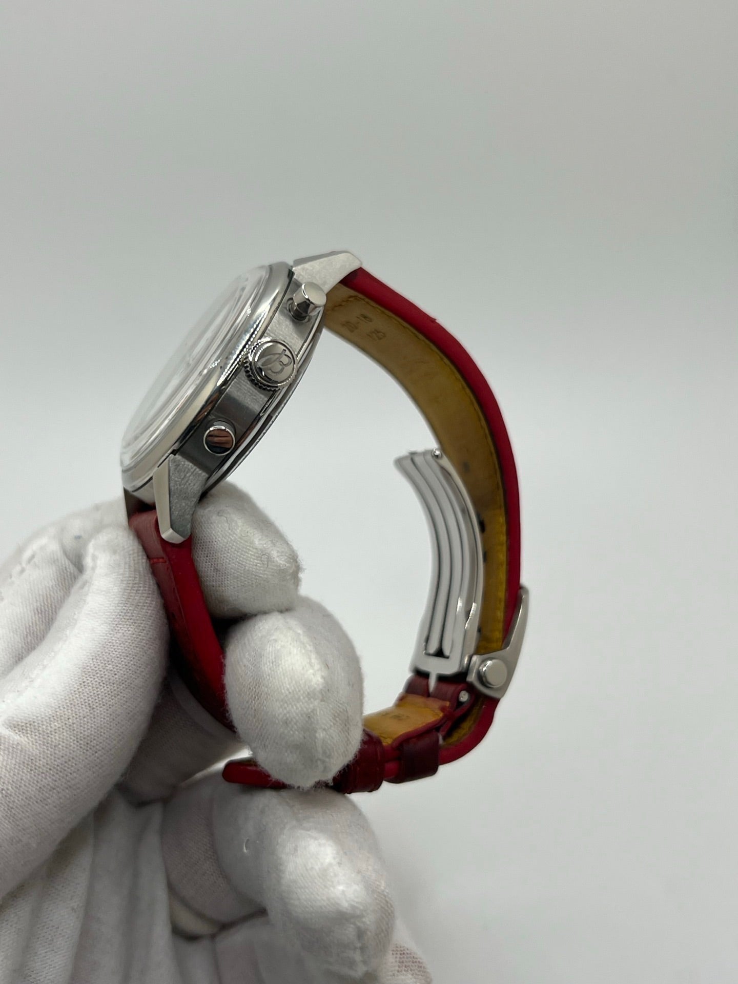 Montre chronographe automatique pour homme au design inspiré des années 60, dotée d’un boîtier en acier de 41 mm, d’un cadran blanc épuré sans chiffres et de compteurs contrastés. Mouvement automatique calibre 01 avec réserve de marche de 70 heures, verre saphir et étanchéité 10 ATM. Bracelet en cuir rouge avec boucle en acier, style sportif et vintage, montre mécanique suisse en très bon état avec coffret et papiers d’origine.