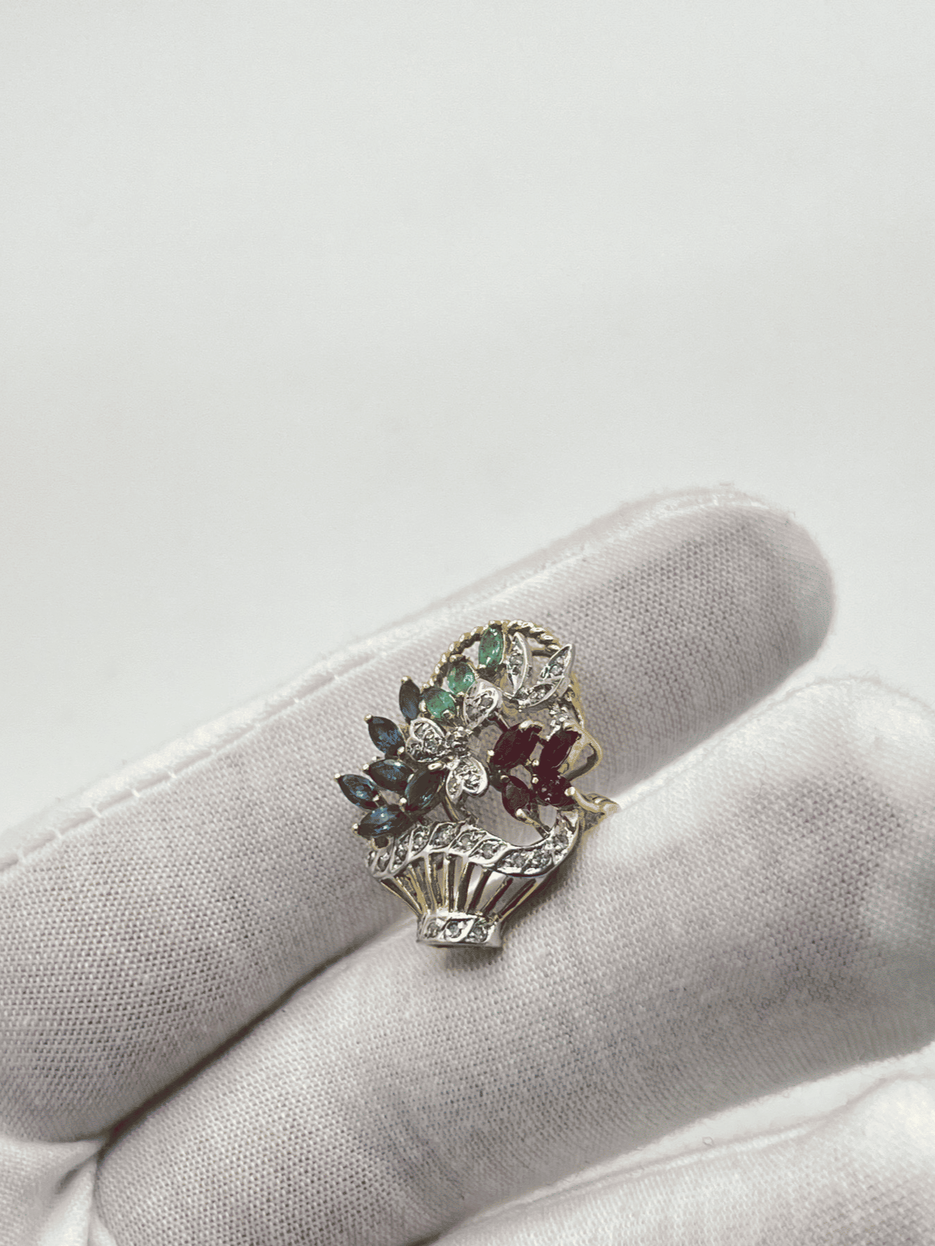 Broche vintage en or jaune et gris sertie de diamants, saphirs, rubis et émeraudes naturelles. Cette élégante broche ancienne allie le raffinement de l’or bicolore à l’éclat de pierres précieuses authentiques. Idéale pour sublimer une tenue avec une touche d’élégance intemporelle, elle incarne le savoir-faire joaillier d’antan. Une pièce rare et précieuse pour les collectionneurs et amateurs de bijoux d’exception.