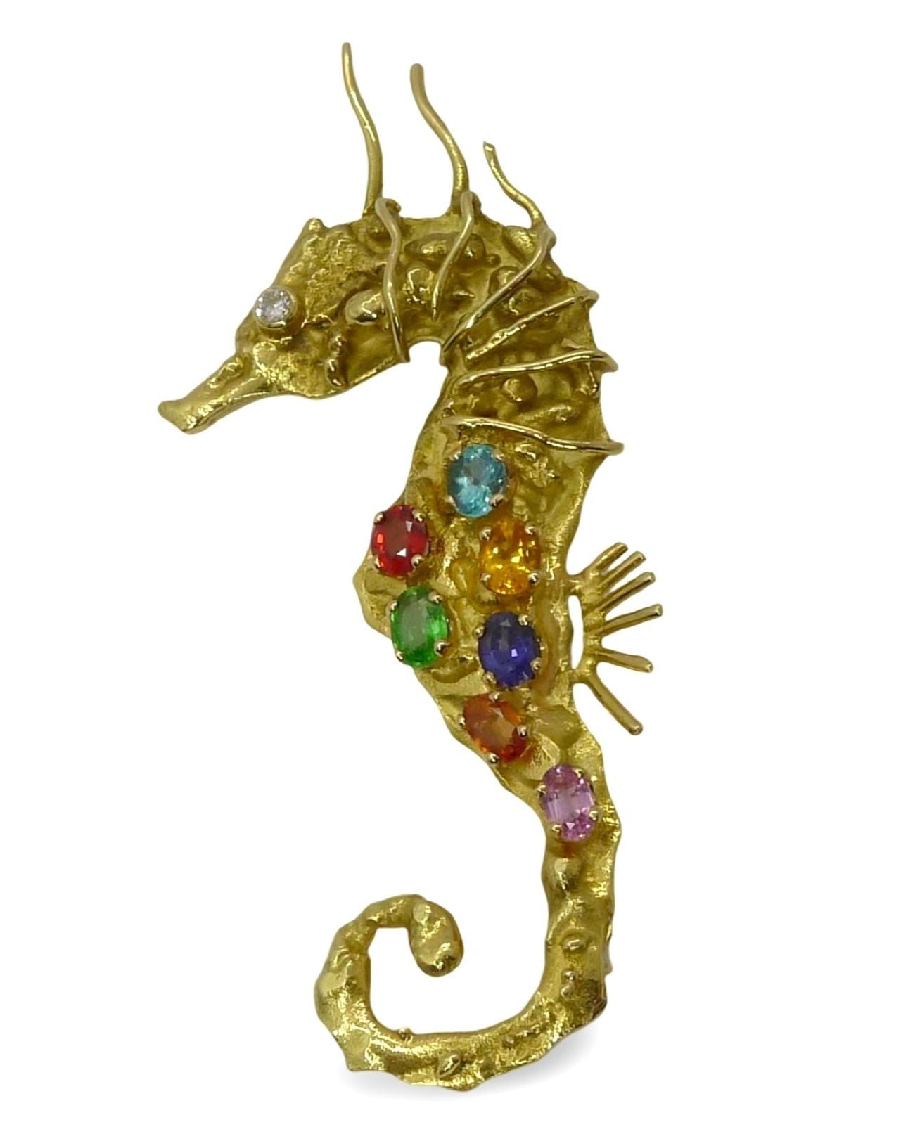 Laissez-vous séduire par cette broche hippocampe en or jaune et pierres fines, une création élégante signée Roland Schad. Ce bijou raffiné allie originalité et savoir-faire artisanal, idéal pour sublimer votre style avec une touche marine et précieuse.
