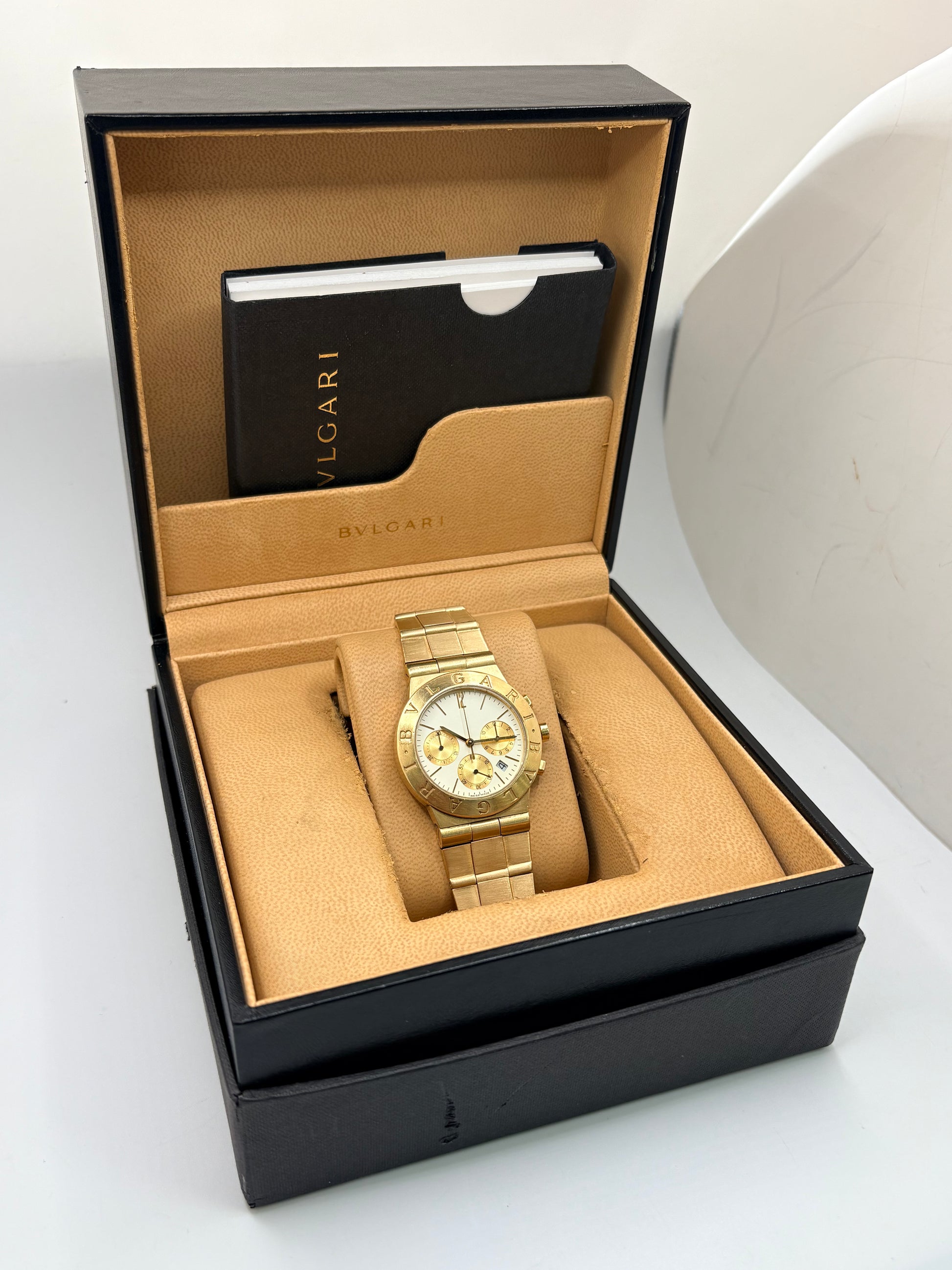 Montre Bulgari Diagono référence CH 35 G en or jaune avec boîtier de 35 mm, d'année inconnue et animée par un mouvement à quartz d'exception comptant 22 pierres. Son cadran blanc à index bâtons avec chronographe et dateur est protégé par un verre saphir et complété par un bracelet en or jaune avec boucle pliante. Cette montre Bulgari d'occasion est en très bon état, révisée en interne et livrée avec son coffret d'origine. Une pièce d'exception disponible à Paris.