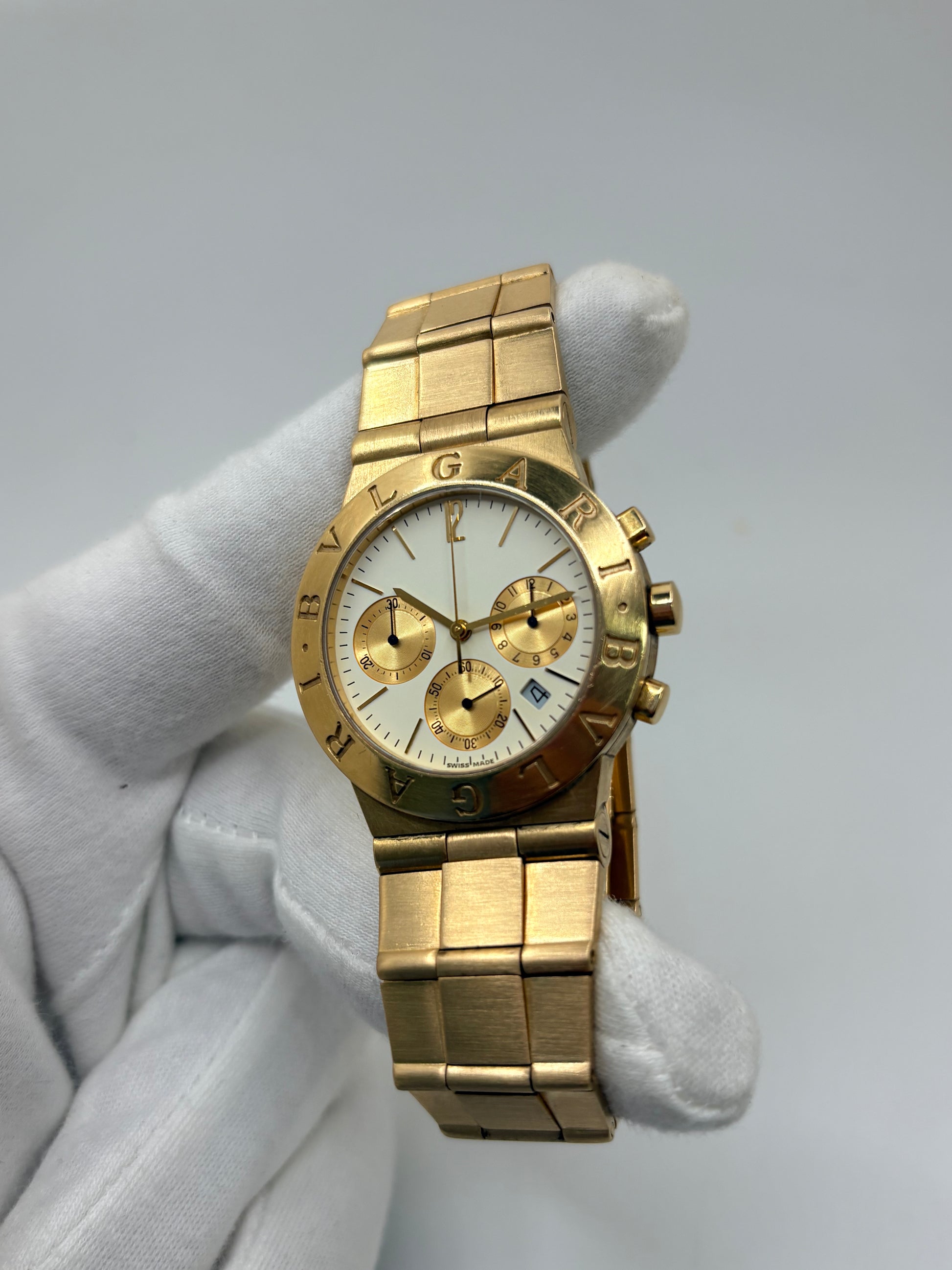 Montre Bulgari Diagono référence CH 35 G en or jaune avec boîtier de 35 mm, d'année inconnue et animée par un mouvement à quartz d'exception comptant 22 pierres. Son cadran blanc à index bâtons avec chronographe et dateur est protégé par un verre saphir et complété par un bracelet en or jaune avec boucle pliante. Cette montre Bulgari d'occasion est en très bon état, révisée en interne et livrée avec son coffret d'origine. Une pièce d'exception disponible à Paris.