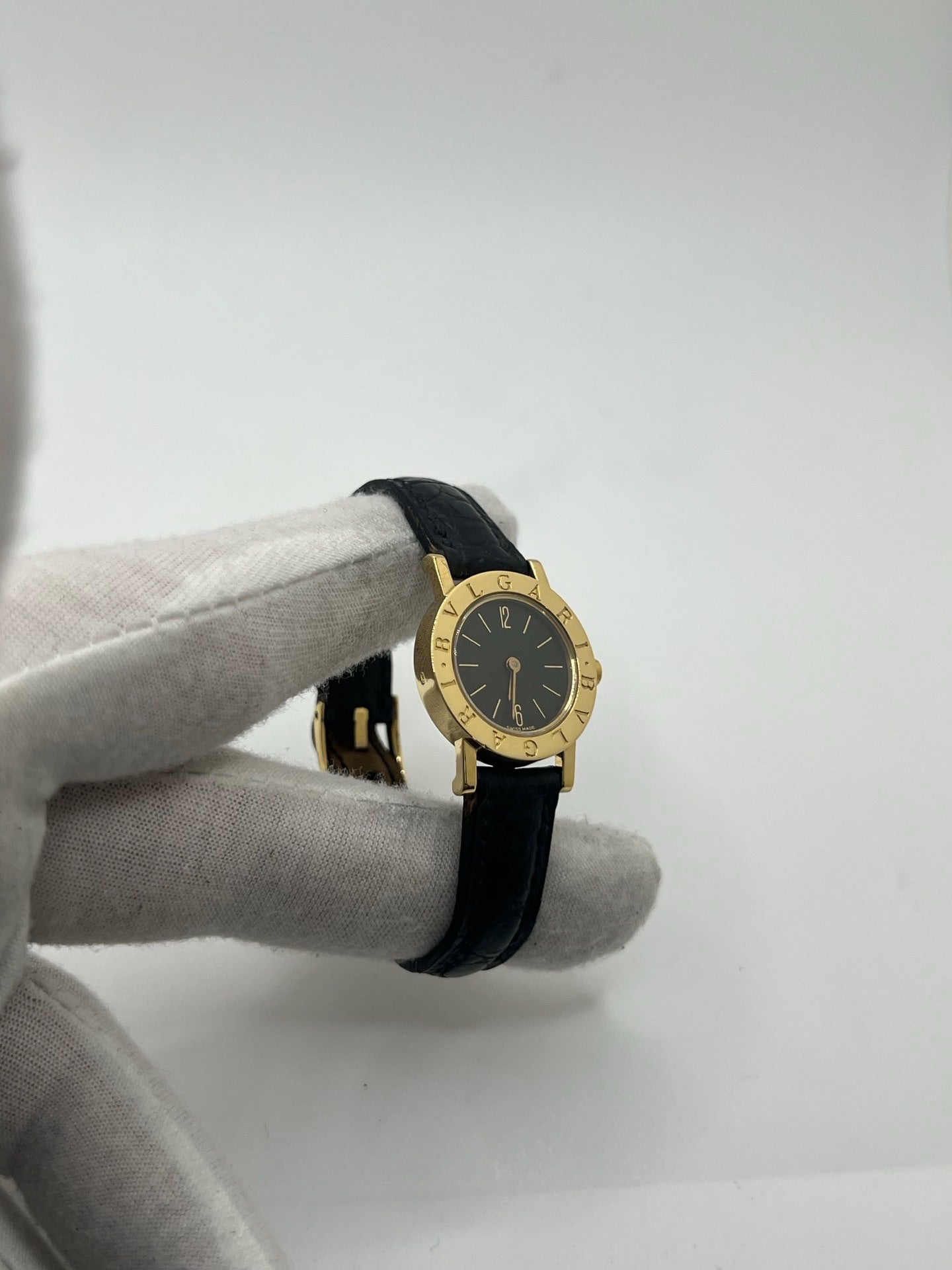 Montre femme Bulgari Bulgari Lady BB 23 GL en or jaune avec boîtier rond de 23 mm, cadran noir élégant et verre saphir. Cette montre de luxe à mouvement quartz est dotée d’un bracelet en cuir noir avec boucle ardillon en or jaune. Modèle emblématique au design intemporel, idéal pour un poignet féminin, alliant raffinement, précision et savoir-faire horloger italien. Parfaite comme montre habillée ou pièce de collection.
