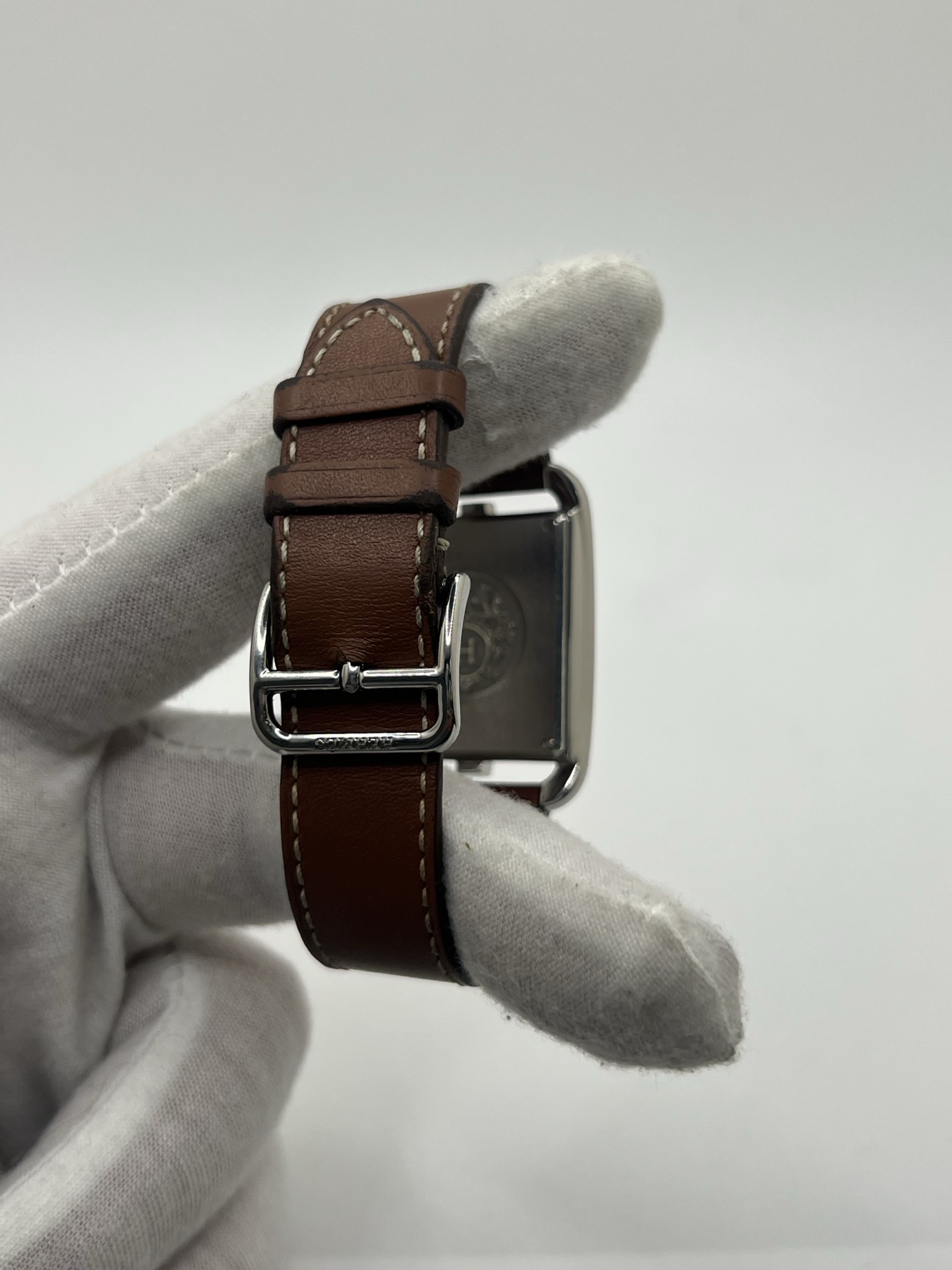 Montre Hermès Cape Cod Grand Modèle en acier inoxydable, boîtier rectangulaire iconique aux lignes élégantes et contemporaines, cadran argenté épuré avec chiffres arabes stylisés et aiguilles fines. Bracelet en cuir signature Hermès offrant confort et raffinement. Mouvement quartz précis. Montre de luxe intemporelle et sophistiquée, idéale pour un porté quotidien ou une tenue habillée, symbole du savoir-faire horloger et du style parisien.