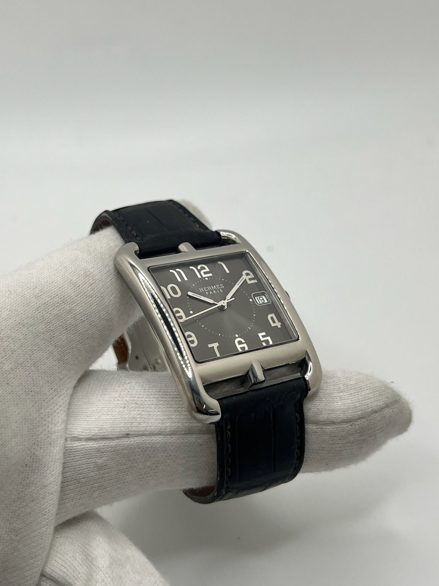 Montre Hermès Cape Cod XL pour homme ou unisexe, modèle emblématique au boîtier en acier de 33 mm. Mouvement quartz, cadran gris à chiffres arabes, bracelet cuir noir avec boucle ardillon. Élégance intemporelle signée Hermès, livrée avec coffret d’origine. Parfait état d’occasion avec légères traces d’usure. Disponible à Paris, prix négociable. Idéal collectionneur ou amateur de montres de luxe.