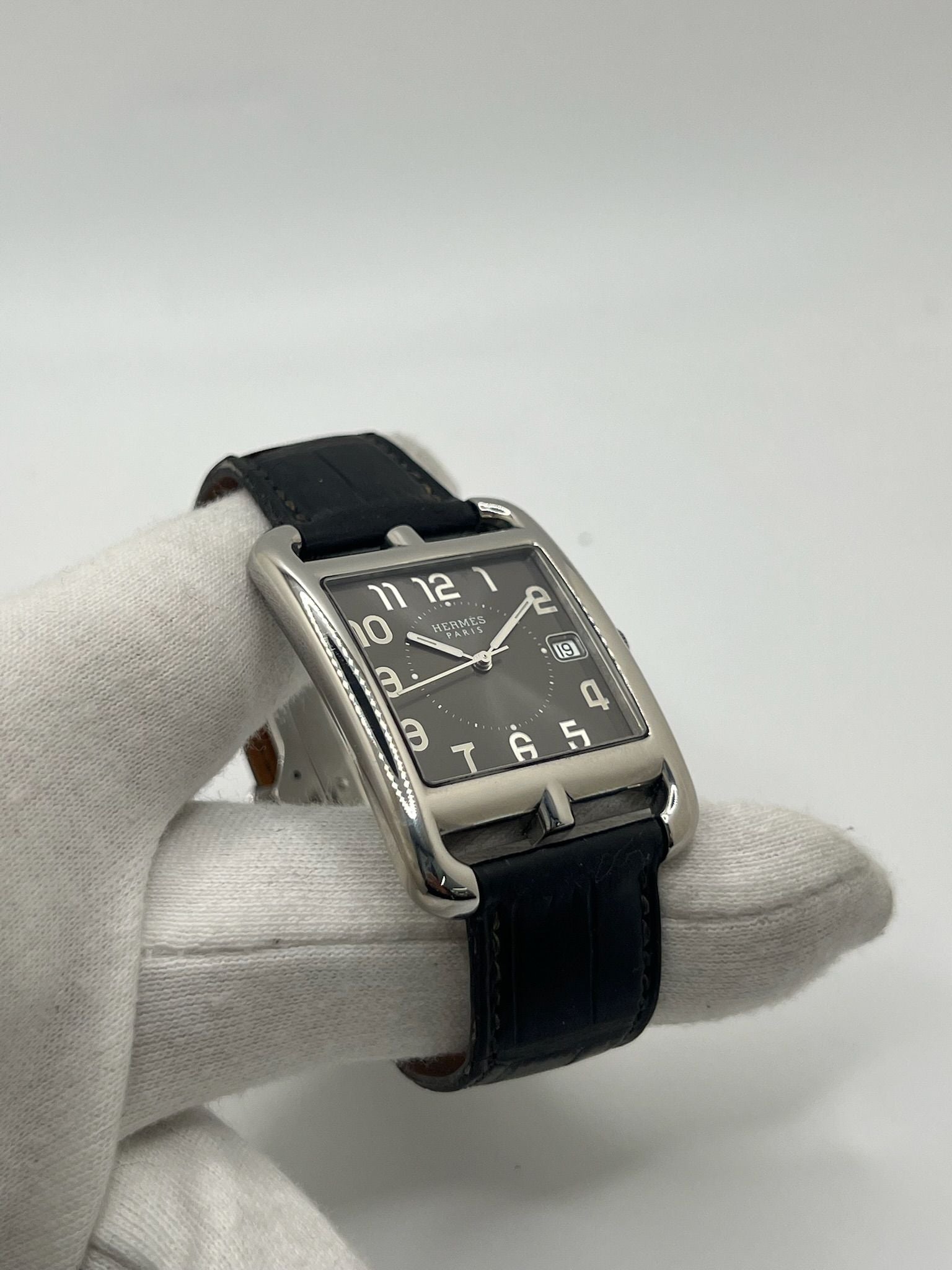 Montre Hermès Cape Cod XL pour homme ou unisexe, modèle emblématique au boîtier en acier de 33 mm. Mouvement quartz, cadran gris à chiffres arabes, bracelet cuir noir avec boucle ardillon. Élégance intemporelle signée Hermès, livrée avec coffret d’origine. Parfait état d’occasion avec légères traces d’usure. Disponible à Paris, prix négociable. Idéal collectionneur ou amateur de montres de luxe.