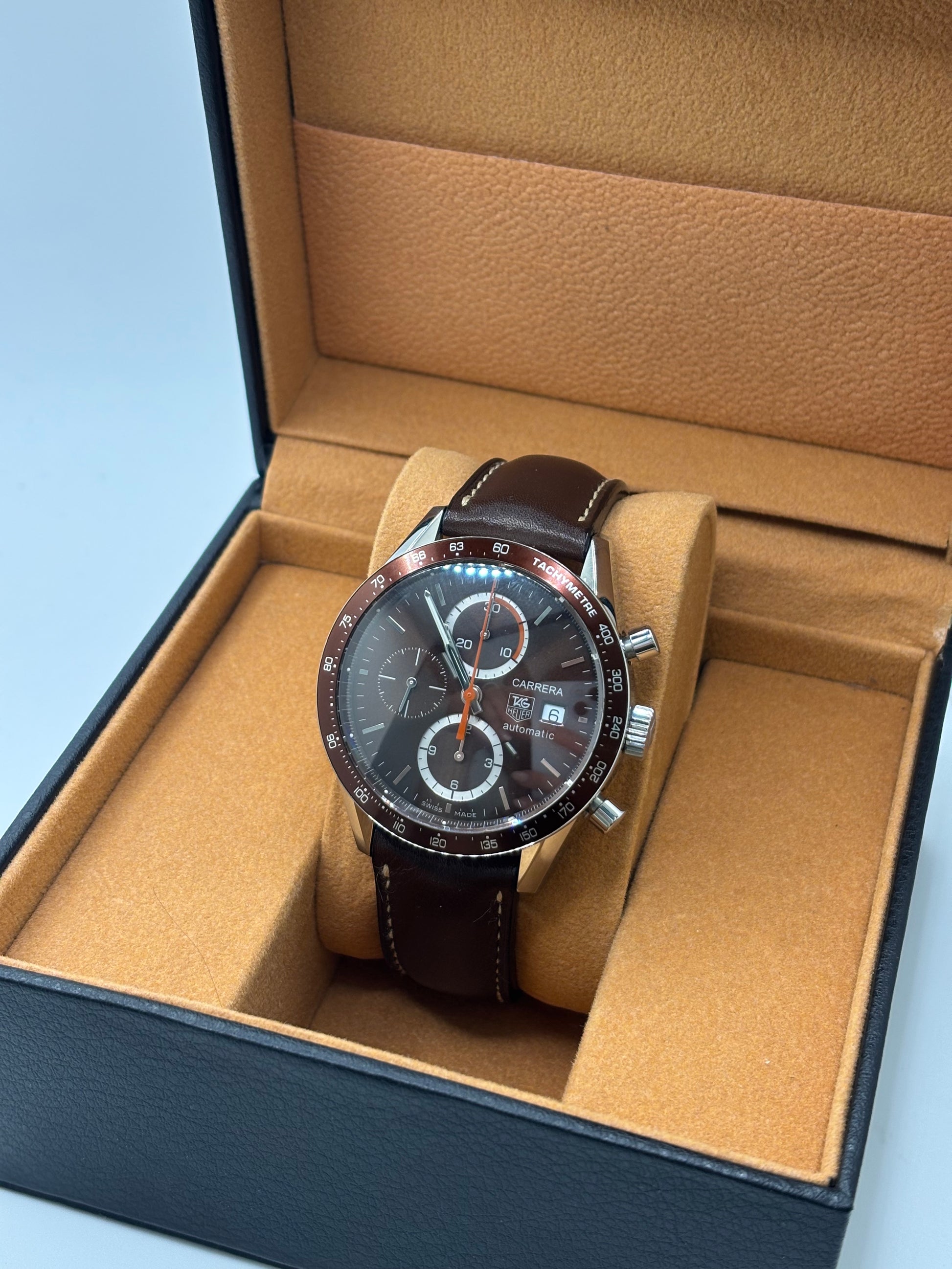 Montre chronographe automatique TAG Heuer Carrera Calibre 16 en acier de 41 mm, dotée d’un cadran brun élégant et d’un verre saphir résistant aux rayures. Ce modèle homme au design sportif et raffiné est équipé d’un mouvement automatique Calibre 16 offrant 42 heures de réserve de marche. Bracelet en cuir brun avec boucle déployante en acier, fonctions chronographe et date, étanchéité 5 ATM, montre suisse de caractère idéale pour un usage quotidien ou une collection horlogère.