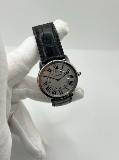 Montre Cartier Ronde Solo en acier avec cadran argent à chiffres romains, mouvement quartz et fonction date. Boîtier rond 36 x 39 mm avec verre saphir et étanchéité 3 ATM. Bracelet en cuir noir avec boucle ardillon en acier. Design classique et élégant, idéal pour homme ou unisexe. Montre d’occasion en très bon état, révisée, avec coffret d’origine.