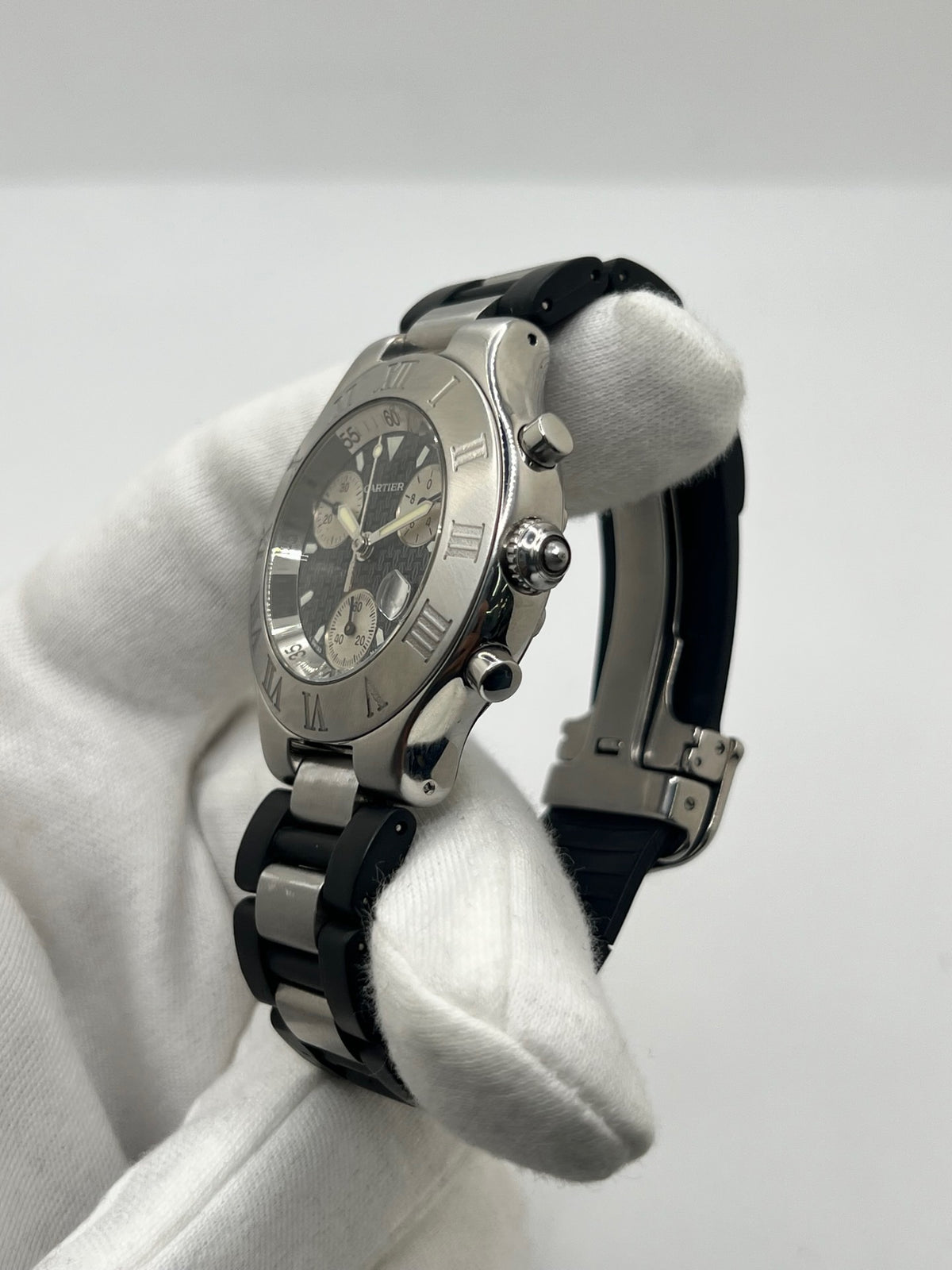 Montre Cartier 21 Chronoscaph 2424 à quartz, dotée d’un boîtier en acier de 38 mm et d’une épaisseur de 10 mm. Son cadran noir est protégé par un verre saphir et accompagné d’un bracelet en caoutchouc avec boucle déployante en acier. Étanche à 10 ATM, cette montre Cartier possède les fonctions chronographe et date. En très bon état, elle présente de légères traces d’usure et a été révisée en interne en septembre 2026.
