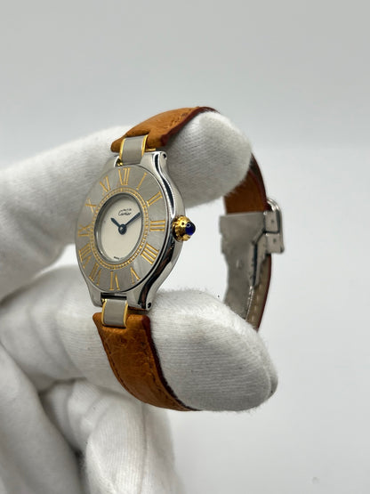 Montre Cartier 21 Must de Cartier 9011 pour femme, équipée d’un mouvement quartz et d’un boîtier en acier de 28 mm. Son cadran blanc offre une esthétique élégante et intemporelle. Cette montre Cartier est montée sur un bracelet brun en cuir avec boucle déployante à plis. En bon état, elle présente des traces d’usure visibles et perceptibles, notamment quelques rayures, éraflures et petites bosses. Révisée en interne en septembre 2026.
