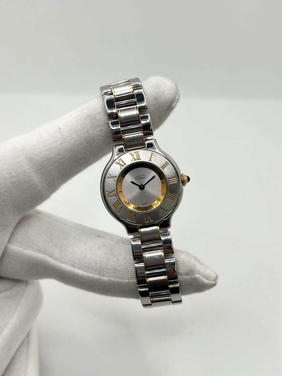 Montre Cartier 21 Must de Cartier référence 1340, modèle vintage au design intemporel. Cette montre de luxe présente un boîtier en acier de 28 mm, un bracelet bicolore en acier et or ainsi qu’un cadran argenté. Équipée d’un mouvement quartz suisse à 7 rubis et d’un verre saphir, elle offre une étanchéité de 3 ATM. Élégante et raffinée, cette Cartier 21 vintage allie le savoir-faire horloger de Cartier à un style classique et sophistiqué.