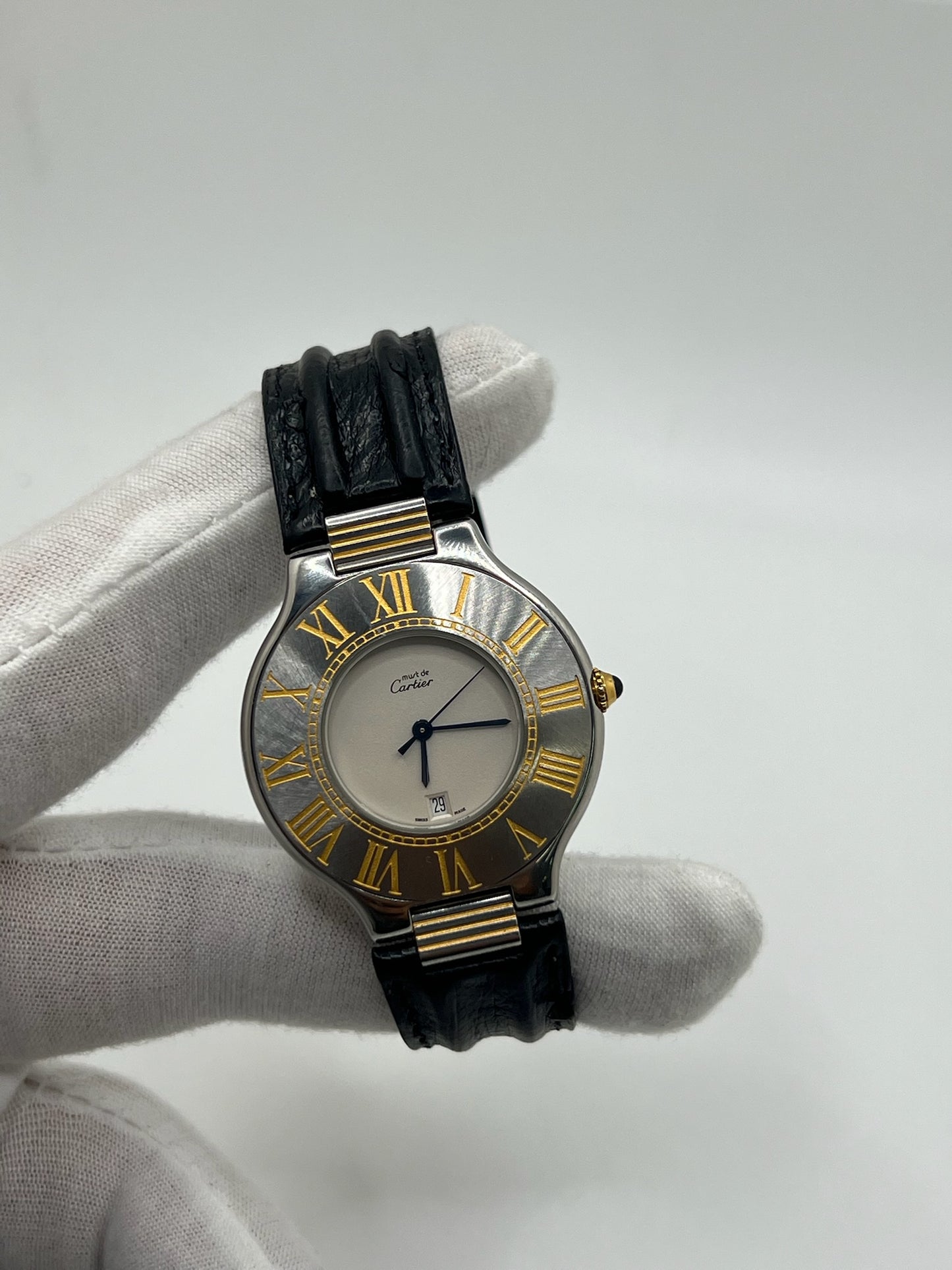 Montre Cartier 21 Must de Cartier avec boîtier 35 mm en or et acier, cadran blanc à chiffres romains, mouvement quartz. Modèle élégant et mixte, équipé d’une boucle déployante sur bracelet cuir noir. Montre de luxe vintage en très bon état, révisée, disponible sans boîte ni papiers d’origine. Idéale pour collectionneur ou amateur de montres emblématiques signées Cartier.