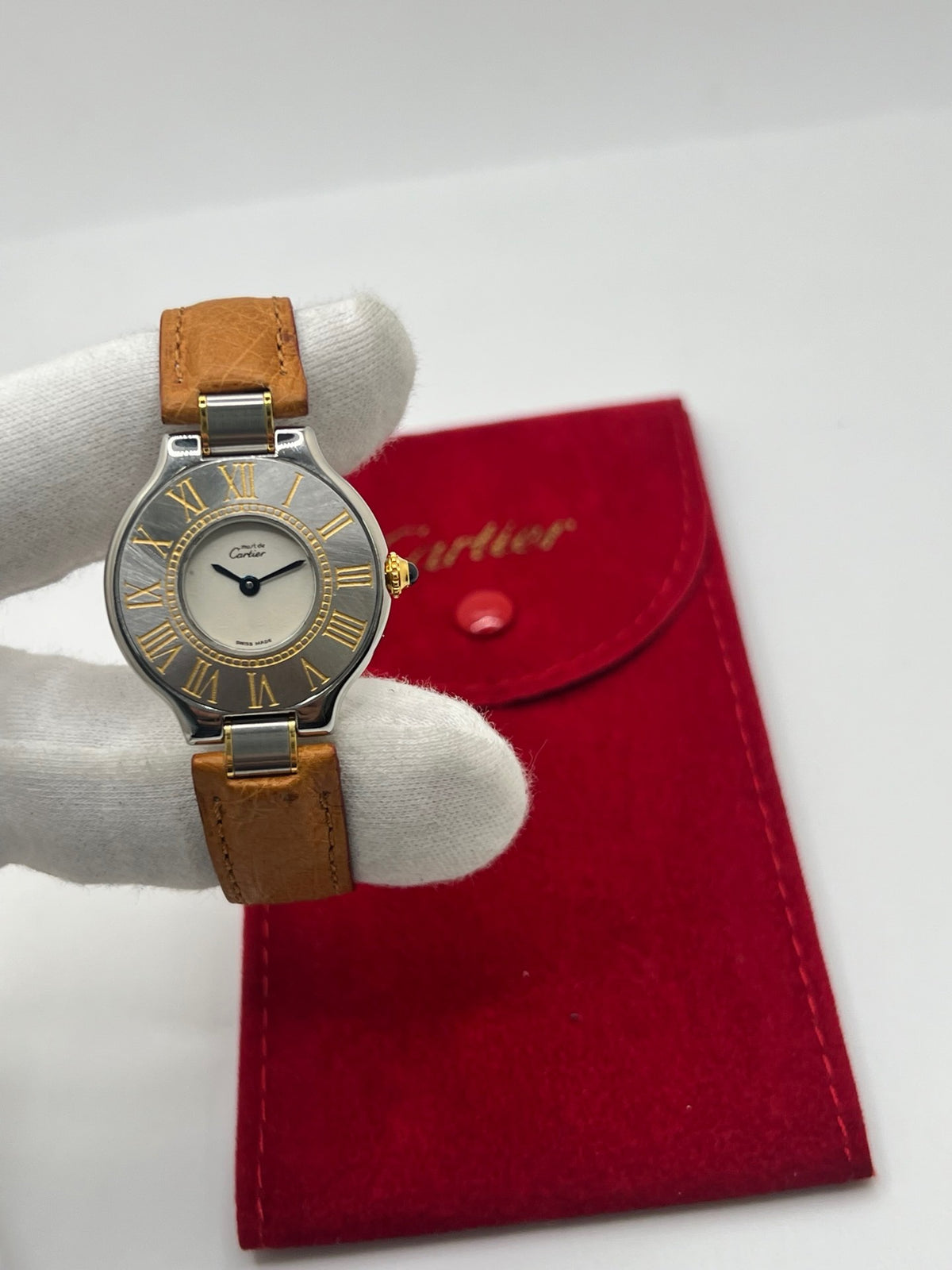 Montre Cartier 21 Must de Cartier 9011 pour femme, équipée d’un mouvement quartz et d’un boîtier en acier de 28 mm. Son cadran blanc offre une esthétique élégante et intemporelle. Cette montre Cartier est montée sur un bracelet brun en cuir avec boucle déployante à plis. En bon état, elle présente des traces d’usure visibles et perceptibles, notamment quelques rayures, éraflures et petites bosses. Révisée en interne en septembre 2026.

